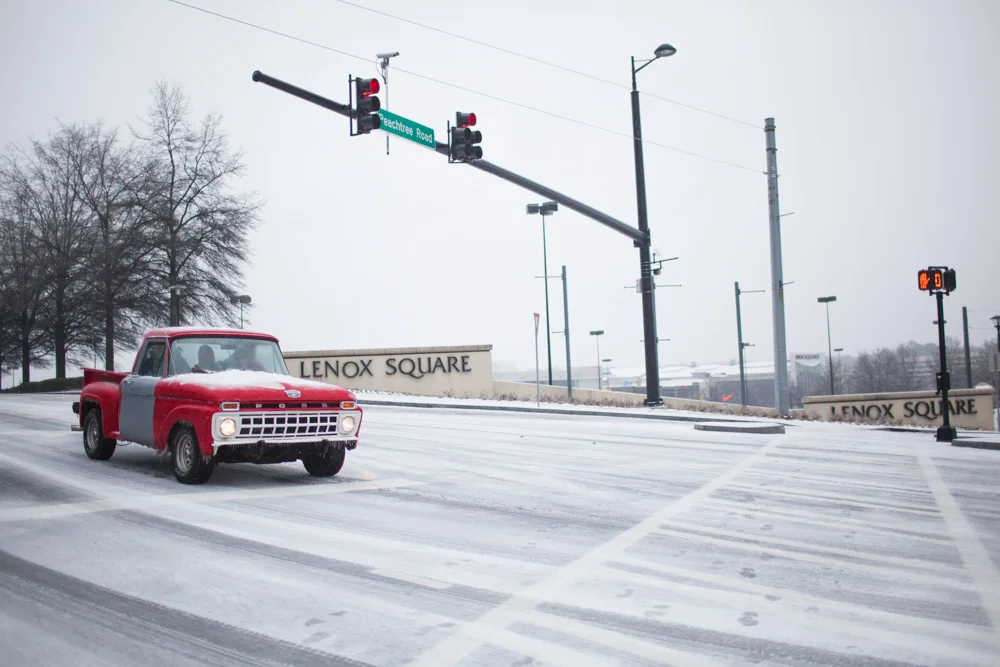 An old truck idles on Lenox Road, across Lenox Square Mall.