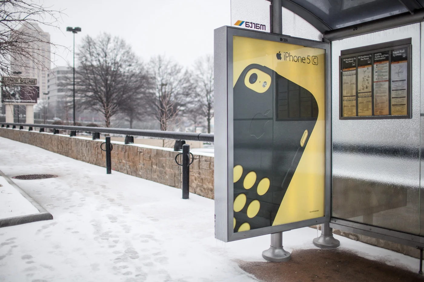 An advertisement for an iPhone 5C on a wall of a MARTA bus station.