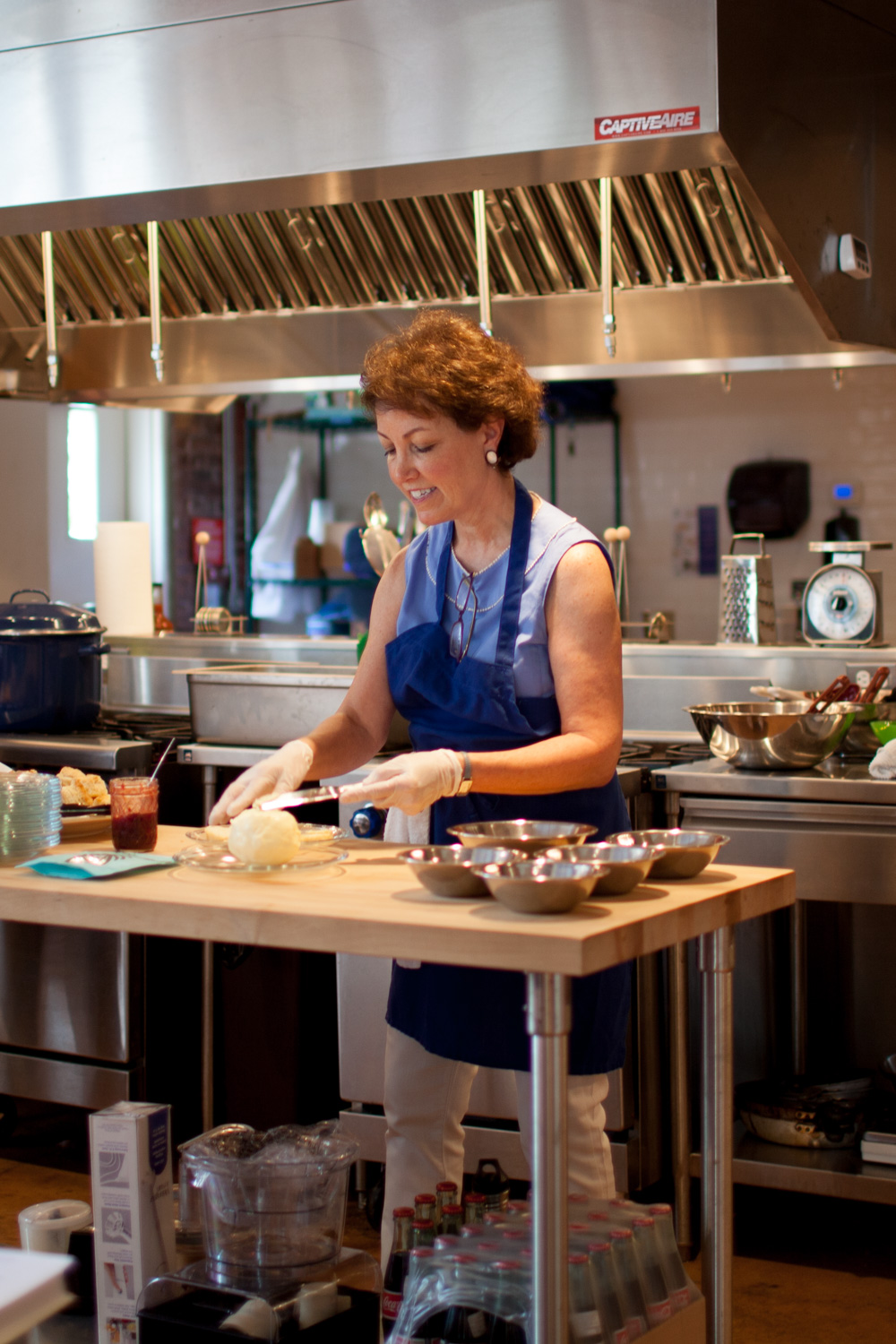  Martha McMillin, owner of Preserving Place, spreads homemade butter on biscuits. 