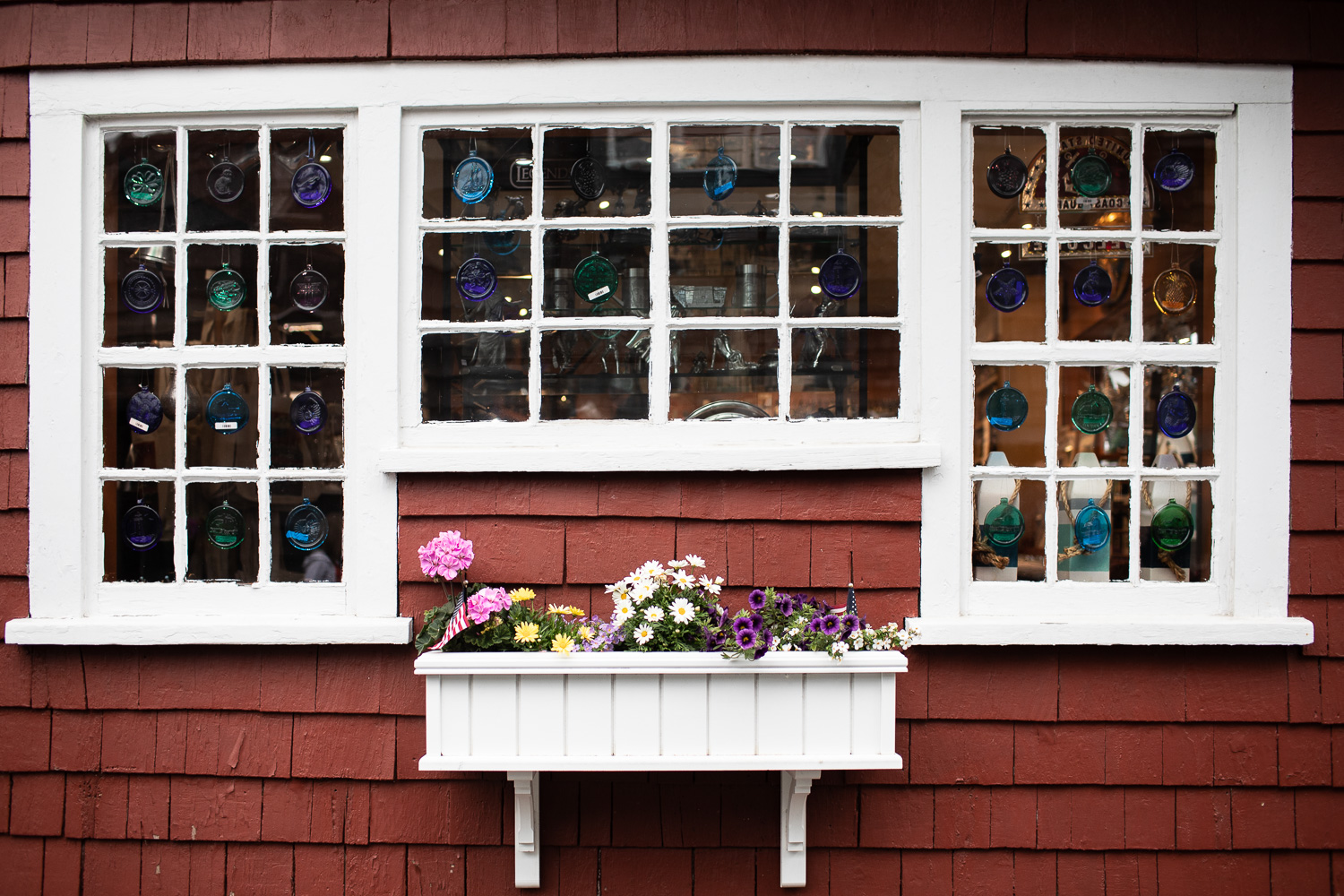 A storefront with flowers and glassware for sale.