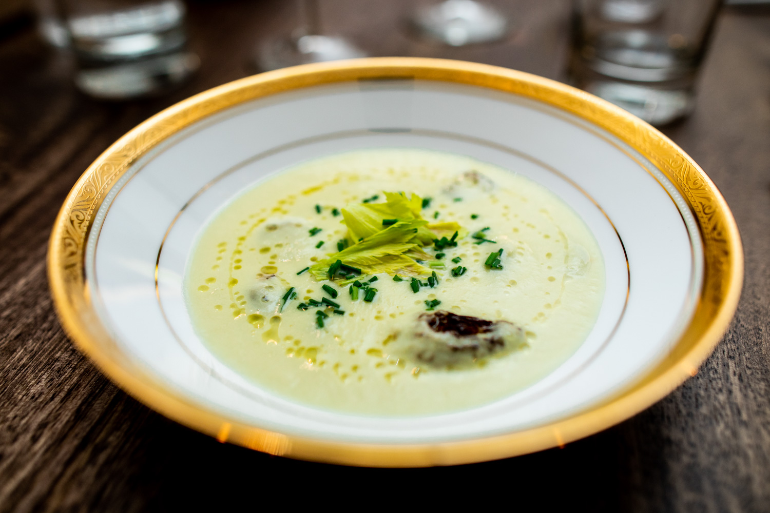 Celery velouté with celery leaves, smoked morels, and lemon oil