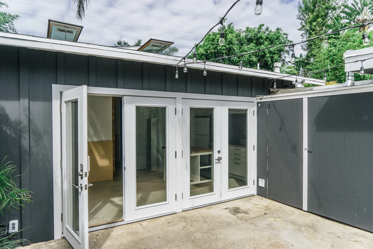 The private courtyard flows to the entry, and minimal facade featuring black and white color pallete. 