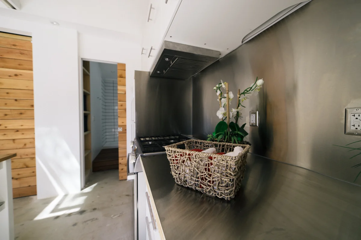 Custom stainless steel counters and backsplash make the compact kitchen ready for work. 