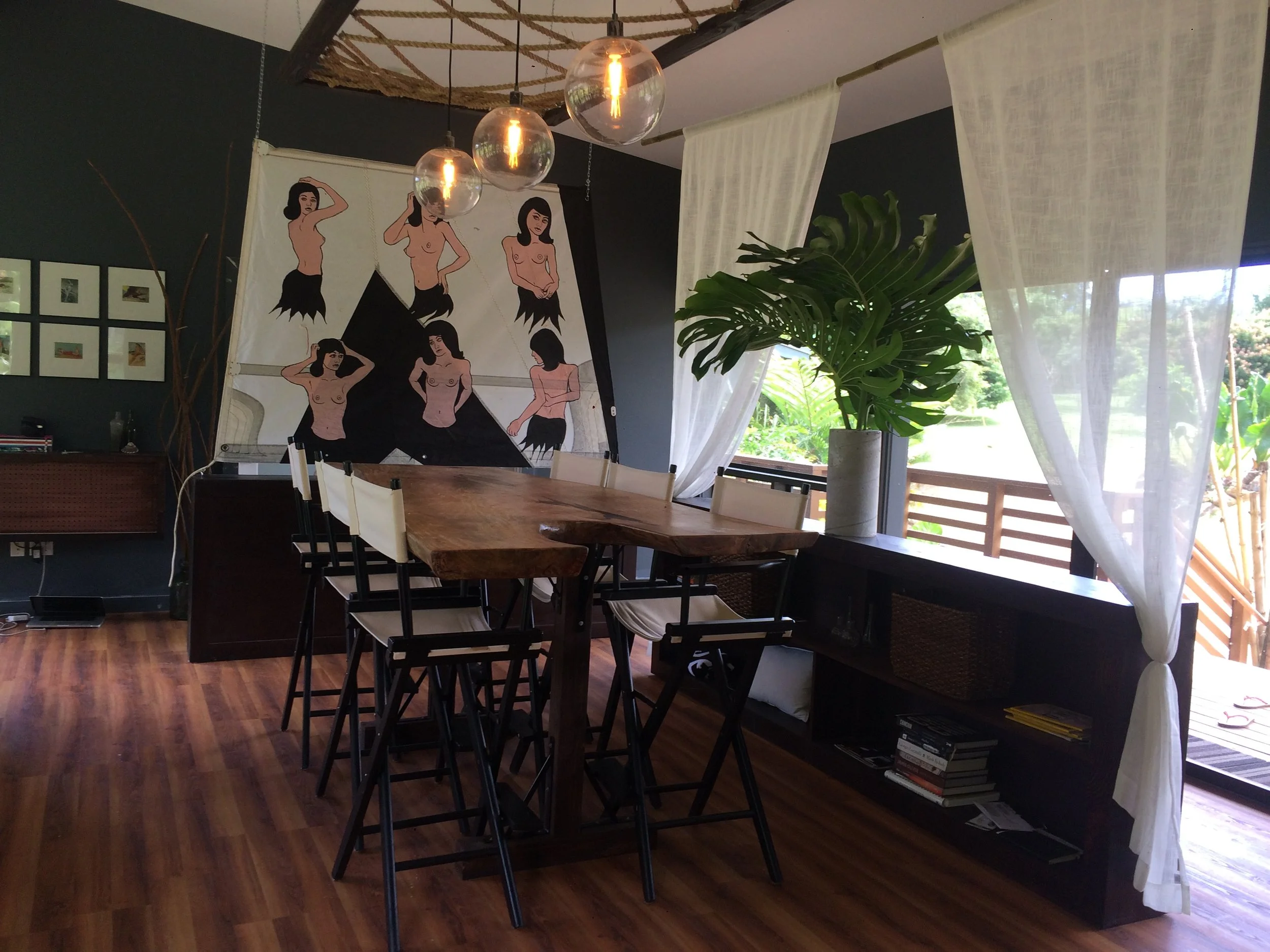  Commissioned art by Scott Chenoweth on sailcloth divides the dining space. Above, a custom rope modern chandelier frames off the dining area.&nbsp; 