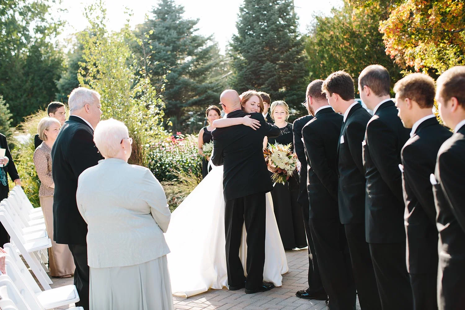 bride hugging father at outdoor altar