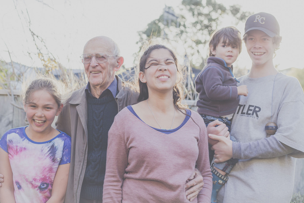 Portrait of a loving grandfather, with some of his great grandchildren, laughing.