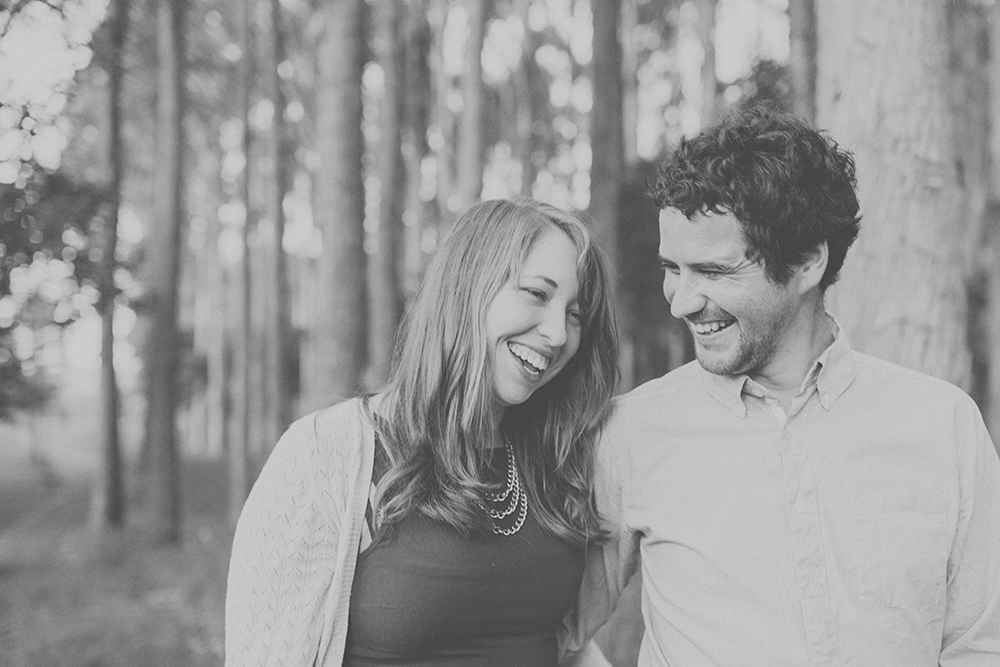 Couple laughing together with trees in background. Photography by Jenny Siaosi.