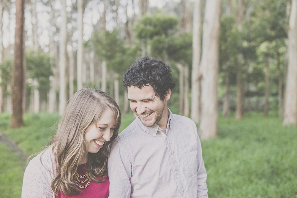 Couple laughing together with trees in background. Photography by Jenny Siaosi.