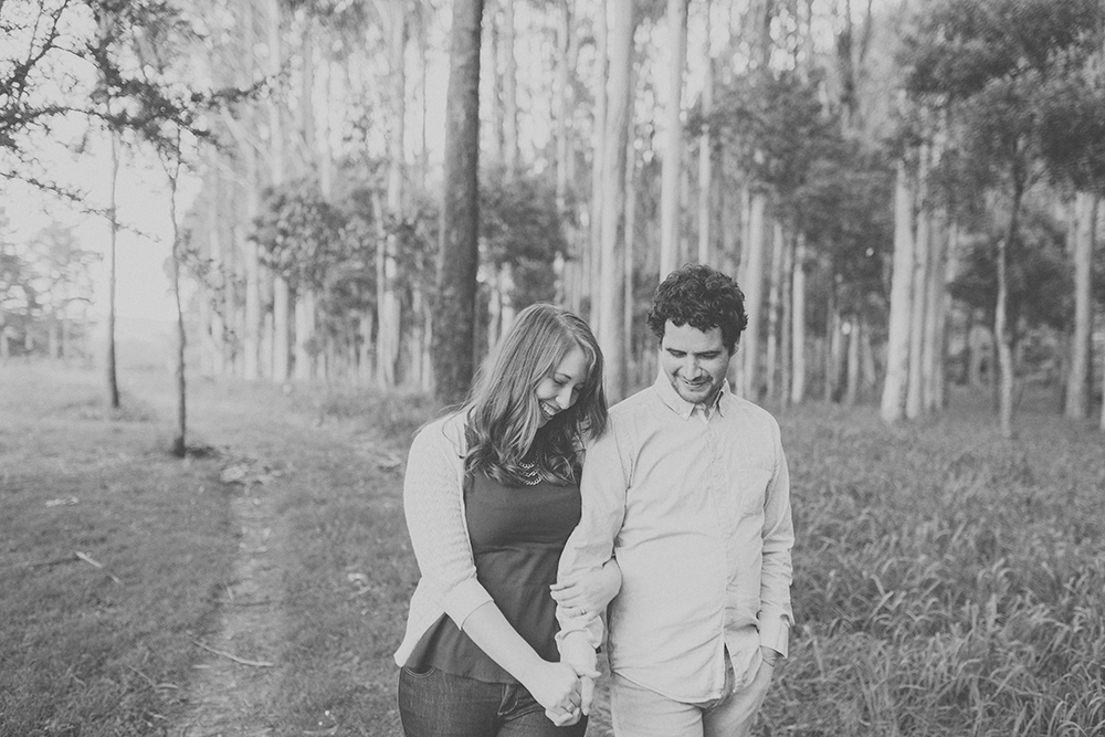 Couple laughing and walking together with trees in background. Photography by Jenny Siaosi.