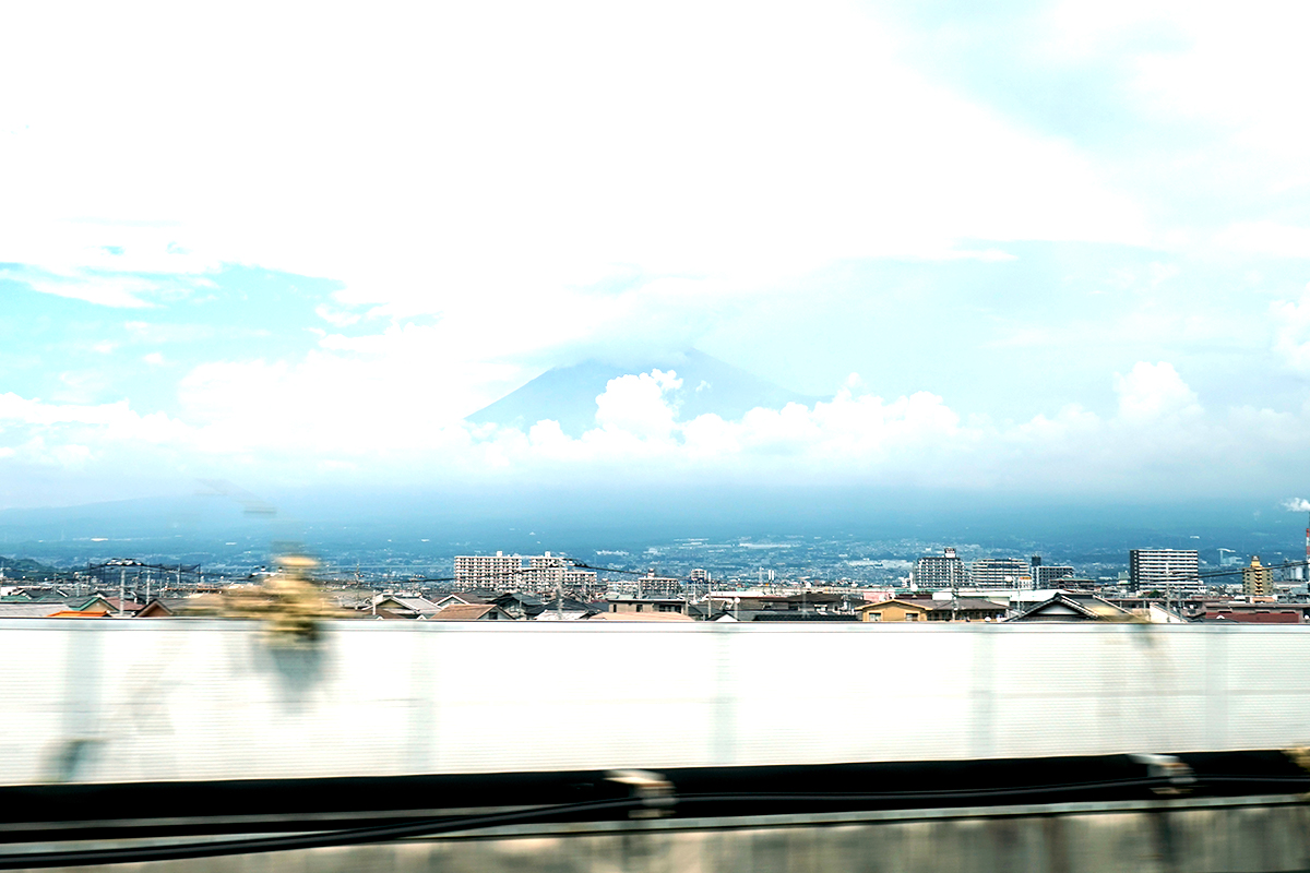   Mt. Fuji peeks out among the clouds, viewable from bustling Tokyo.  