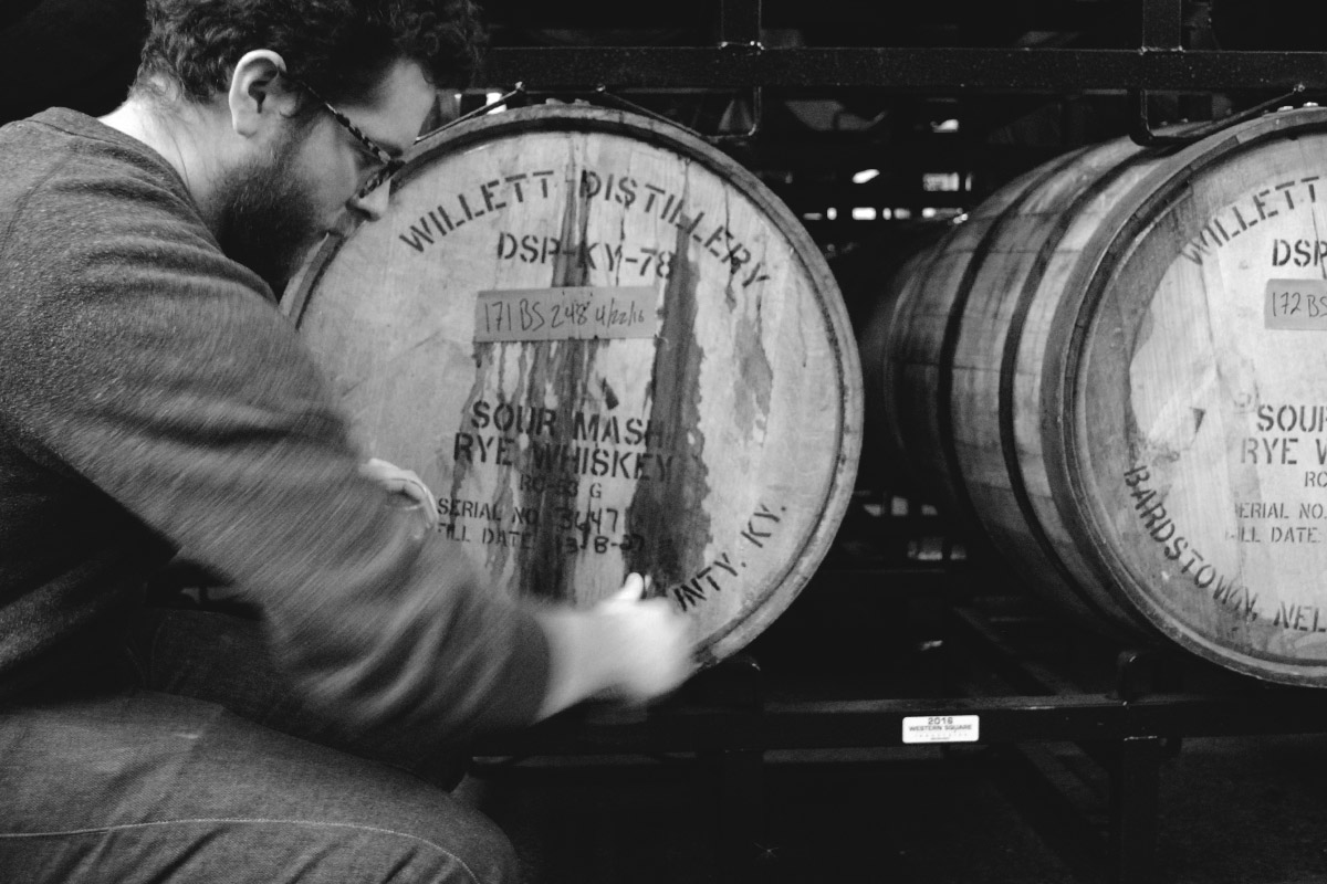   Mike Schallau taps a sample of Bourbon-aged  The Abduction  from the barrel.  