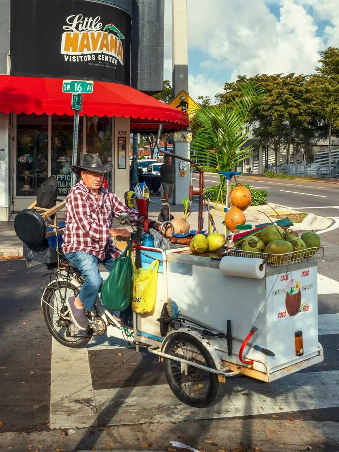 Coco frio street vendor on cargo bike trike at Calle Ocho, Little Havana, Miami — fresh coconut street food cart.