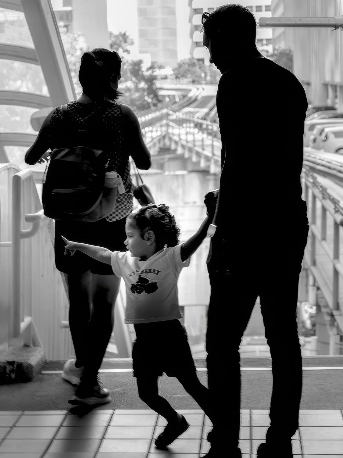Family on Metromover bridge Black and white silhouette of a family with a young child on a Metromover pedestrian bridge in downtown Miami