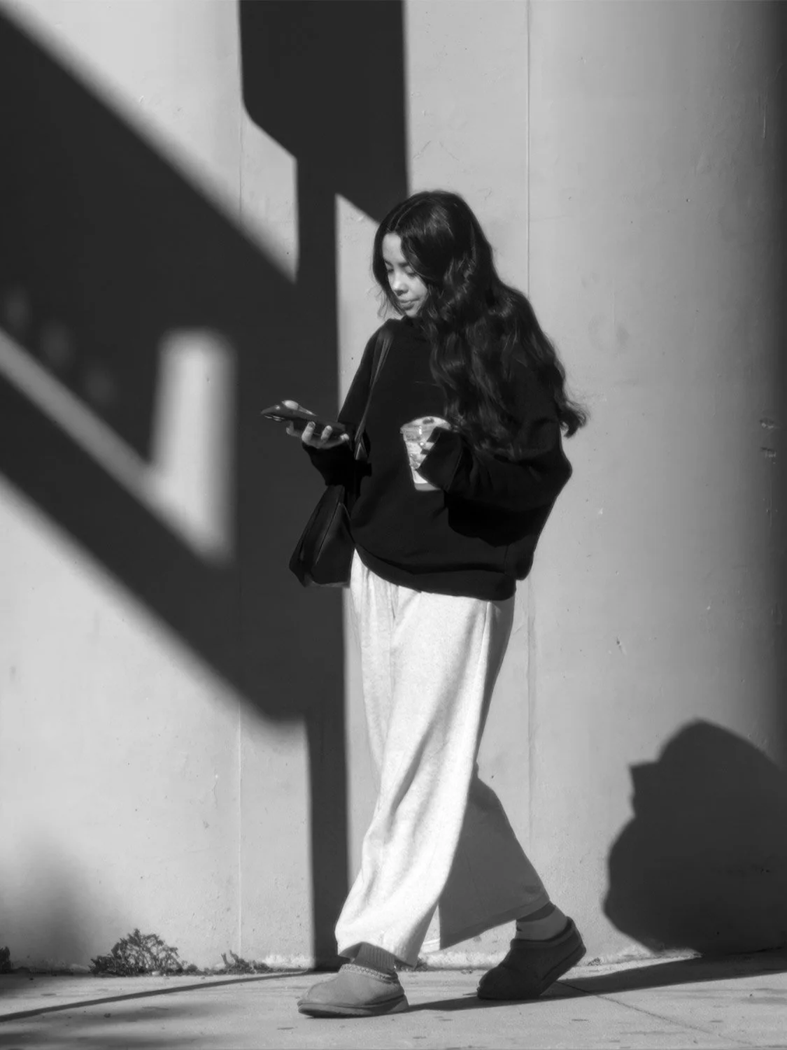 Street style fashion: oversized sweatshirt, wide-leg trousers, UGG slippers, casual minimalist women's outfit 2024.