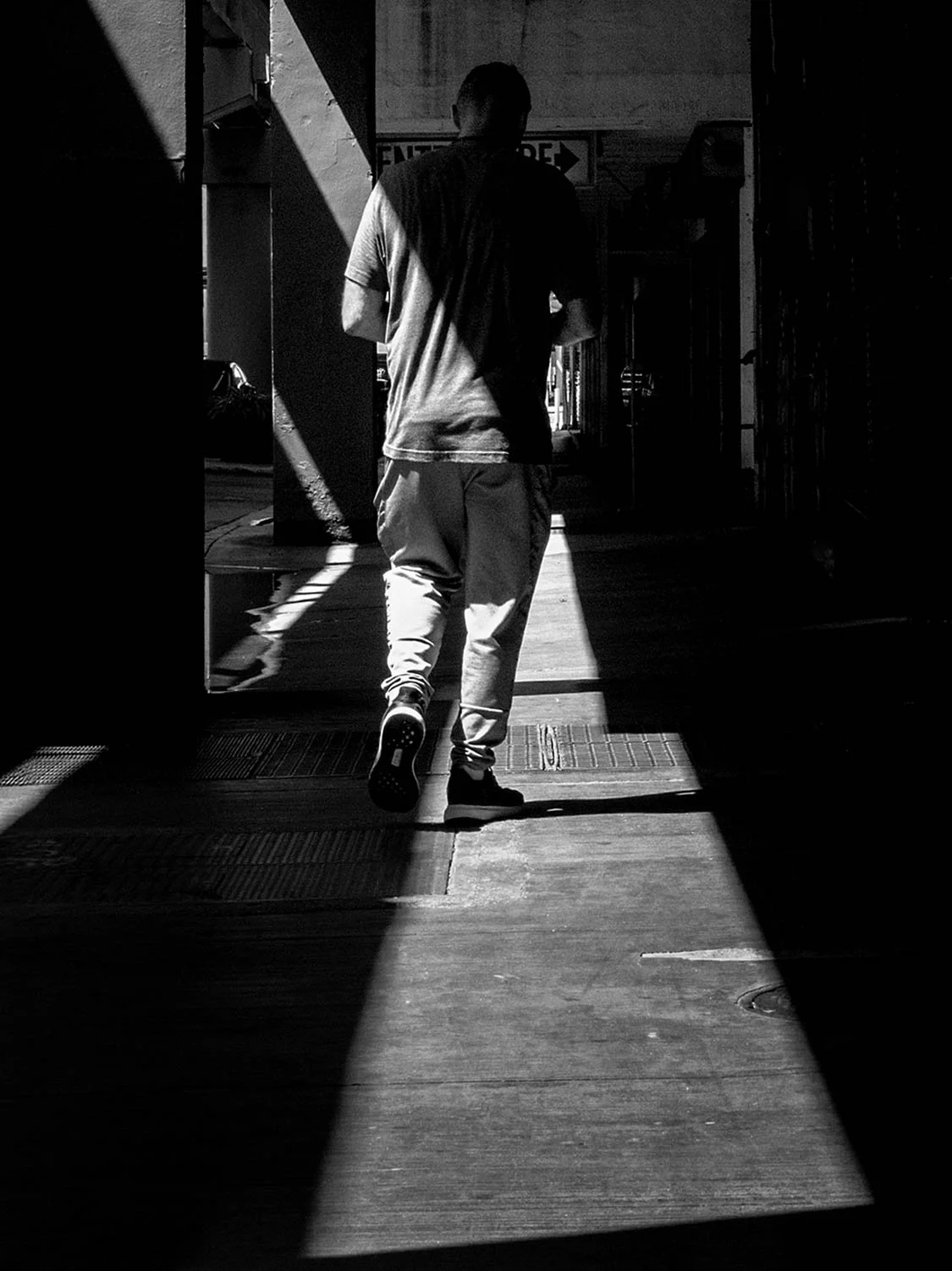 downtown Miami street photography black and white man walking urban architecture light shadow