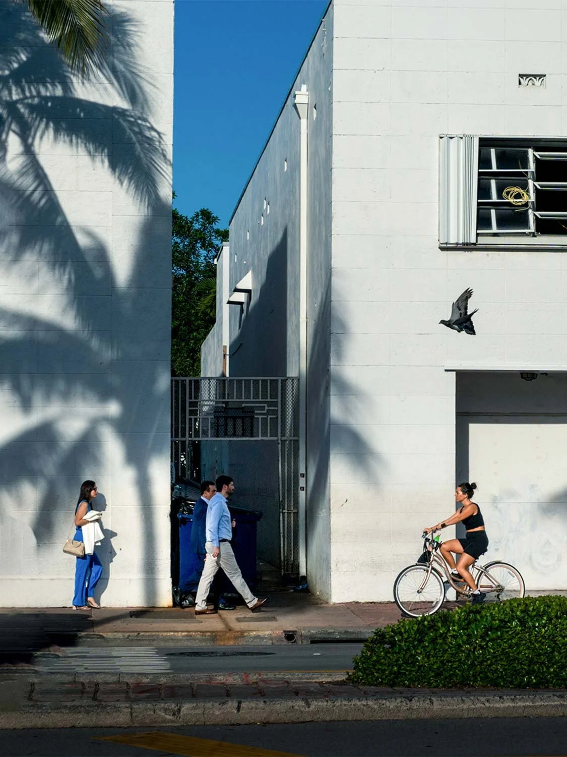 South Beach street scene Art Deco architecture palm shadows cyclists pedestrians Miami urban lifestyle photography