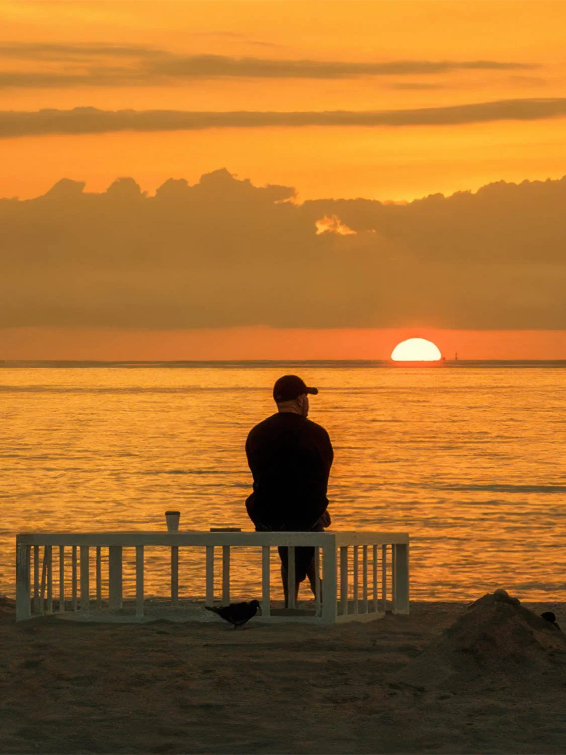 South Beach sunrise ocean view silhouette man bench golden sky Miami beach sunrise photography
