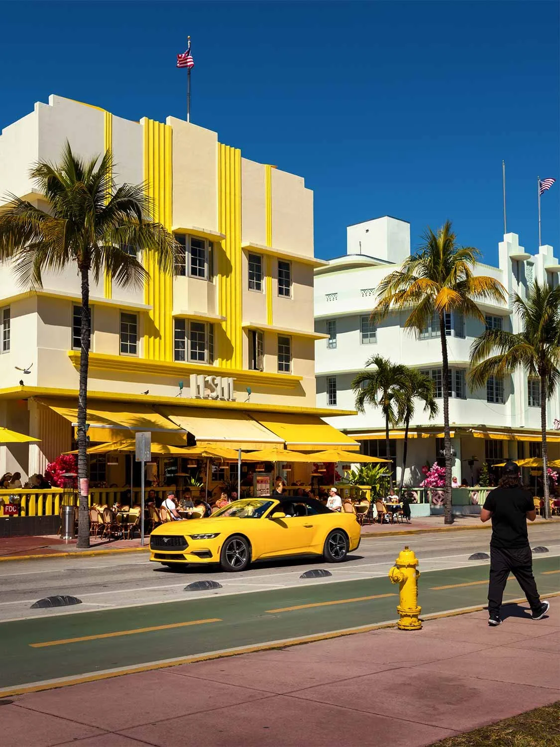 Miami Beach Ocean Drive Art Deco hotel yellow Mustang convertible palm trees outdoor cafe South Beach Florida