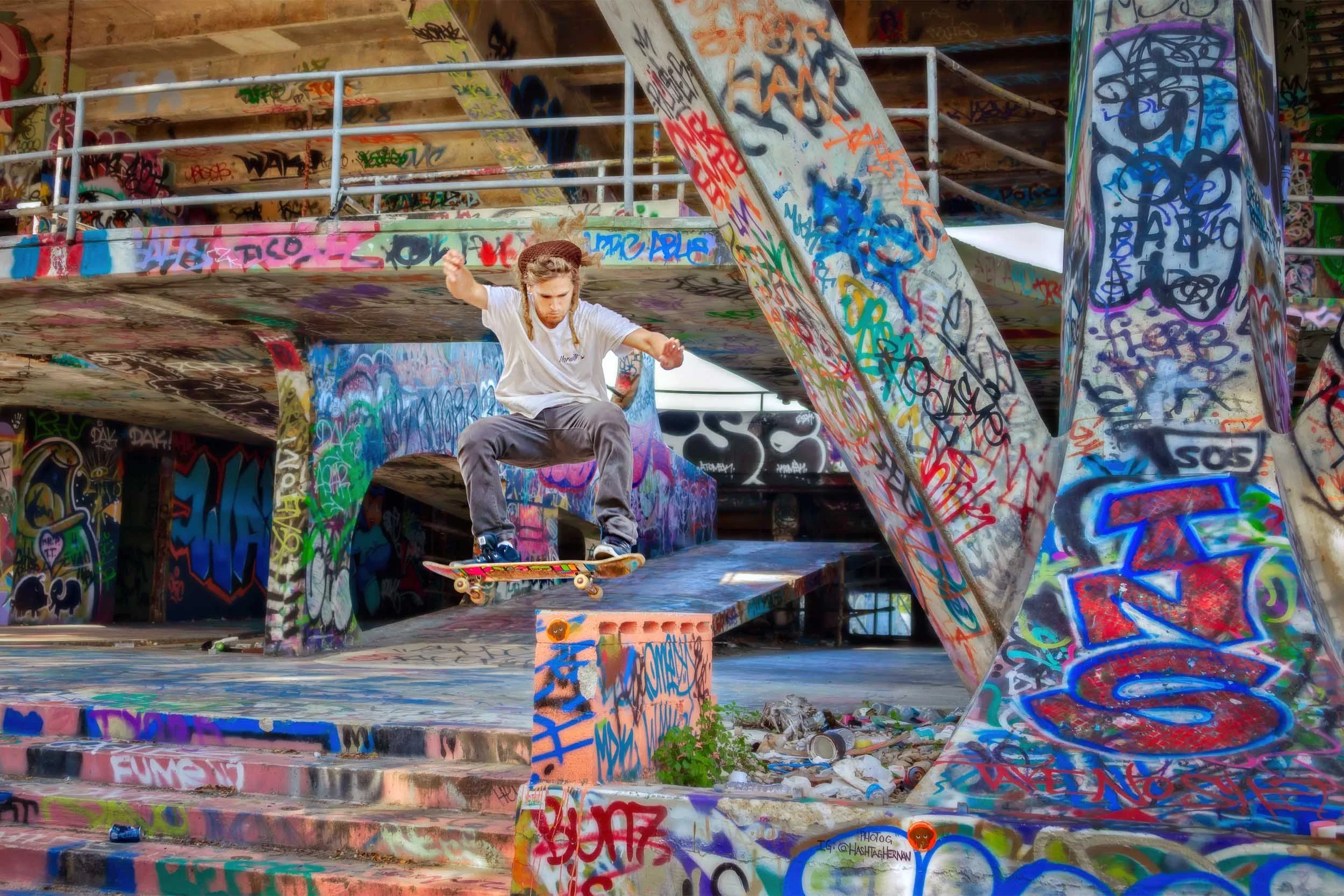 Skateboarder catching air beneath the graffiti-covered grandstand of the abandoned Miami Marine Stadium