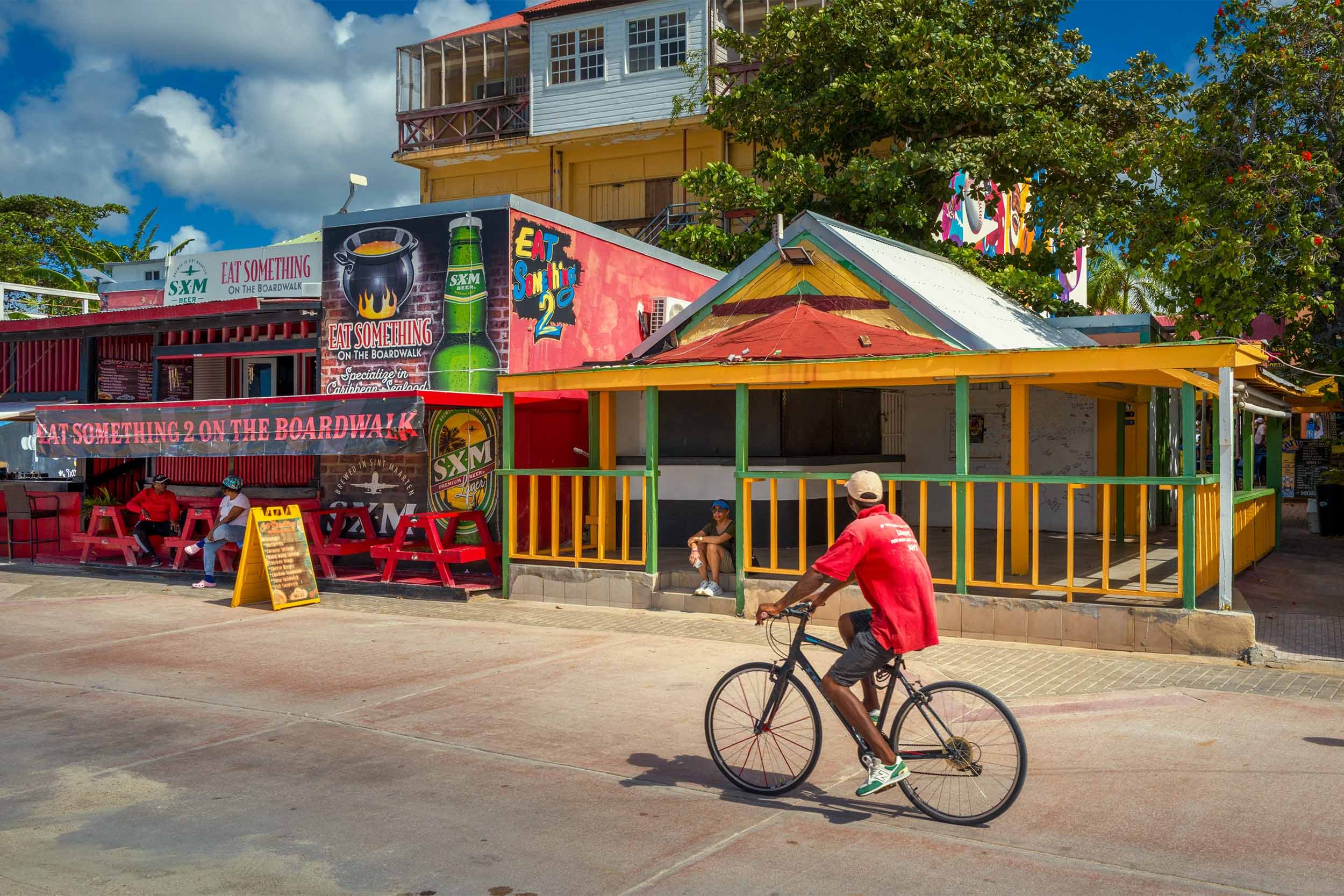 Riding a bike past the bars on the Malecon in Philipsburg