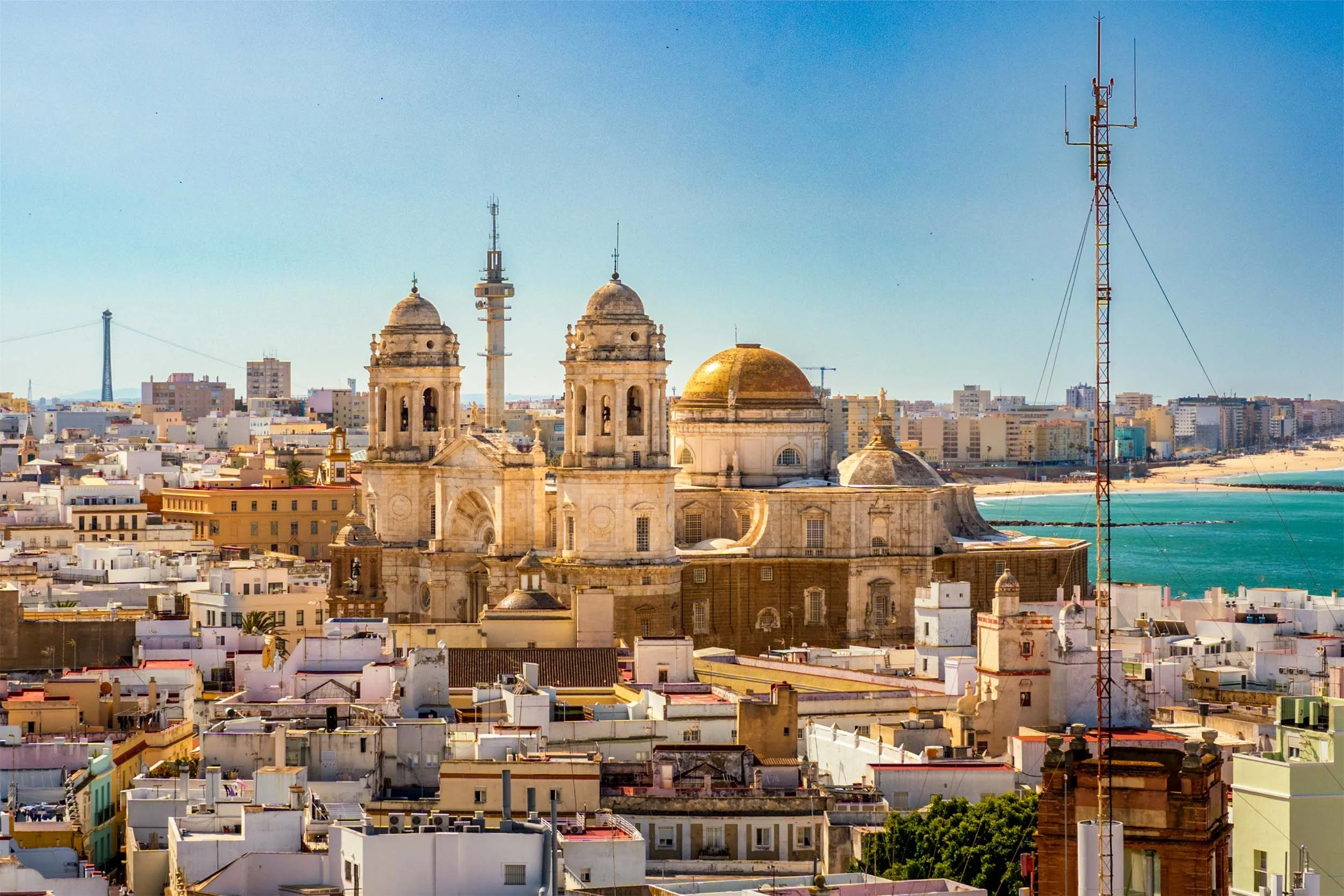 Aerial view of Cadiz Spain old town with cathedral golden dome, white rooftops, and turquoise Atlantic coastline
