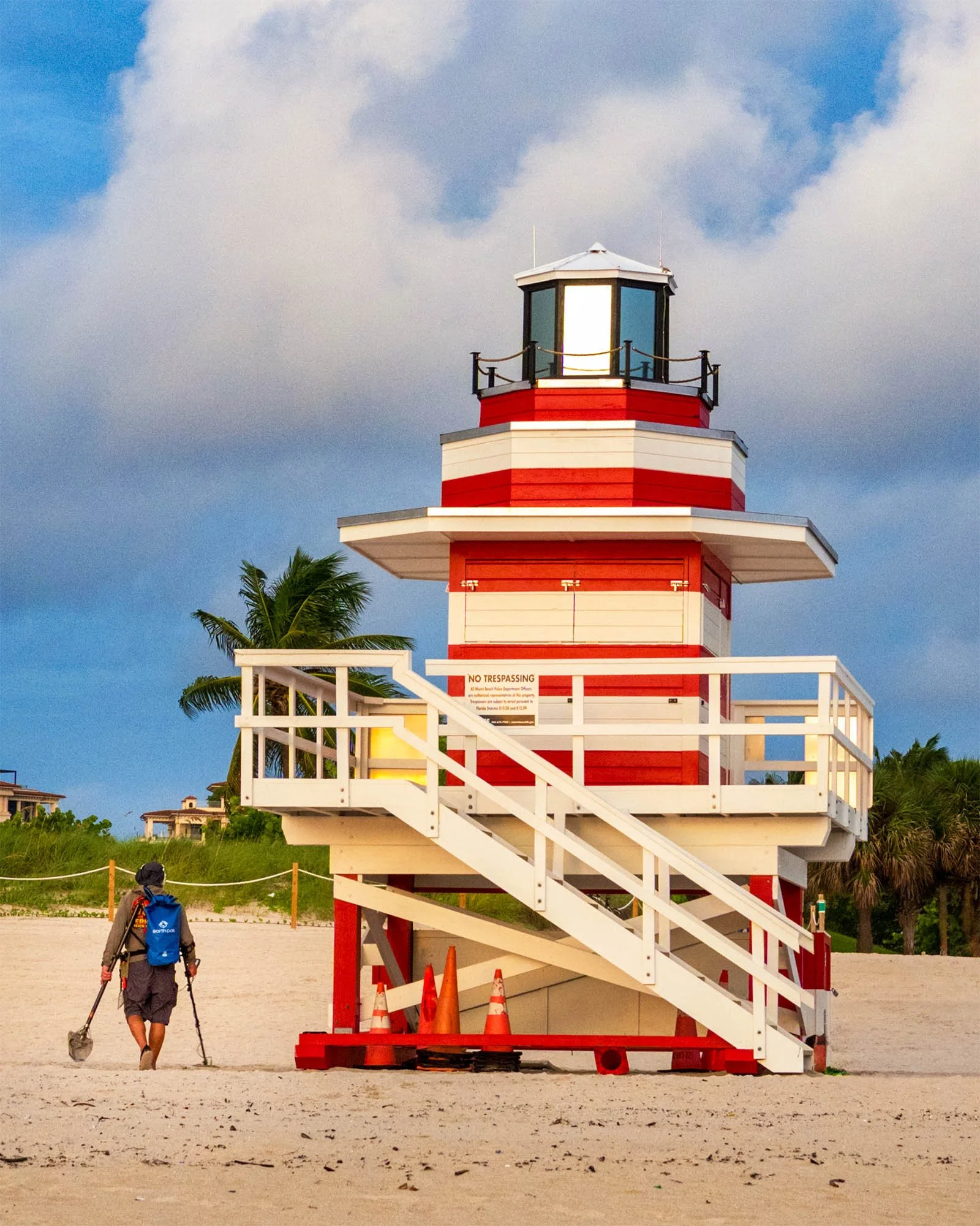 New Jetty lifeguard tower on the beach at South Pointe with traffic cones at the base and a man with a metal detector walking past