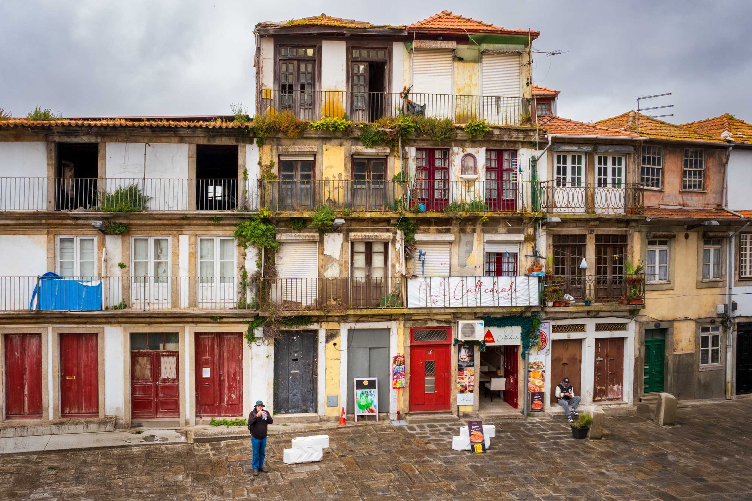 Decaying building facade in a cobblestone square, Porto old town