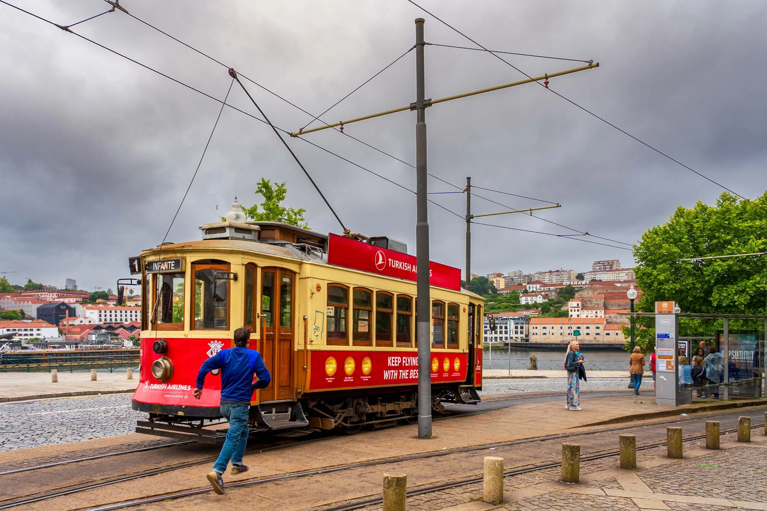 Tram stop along the Ribeira waterfront with Douro river cityscape