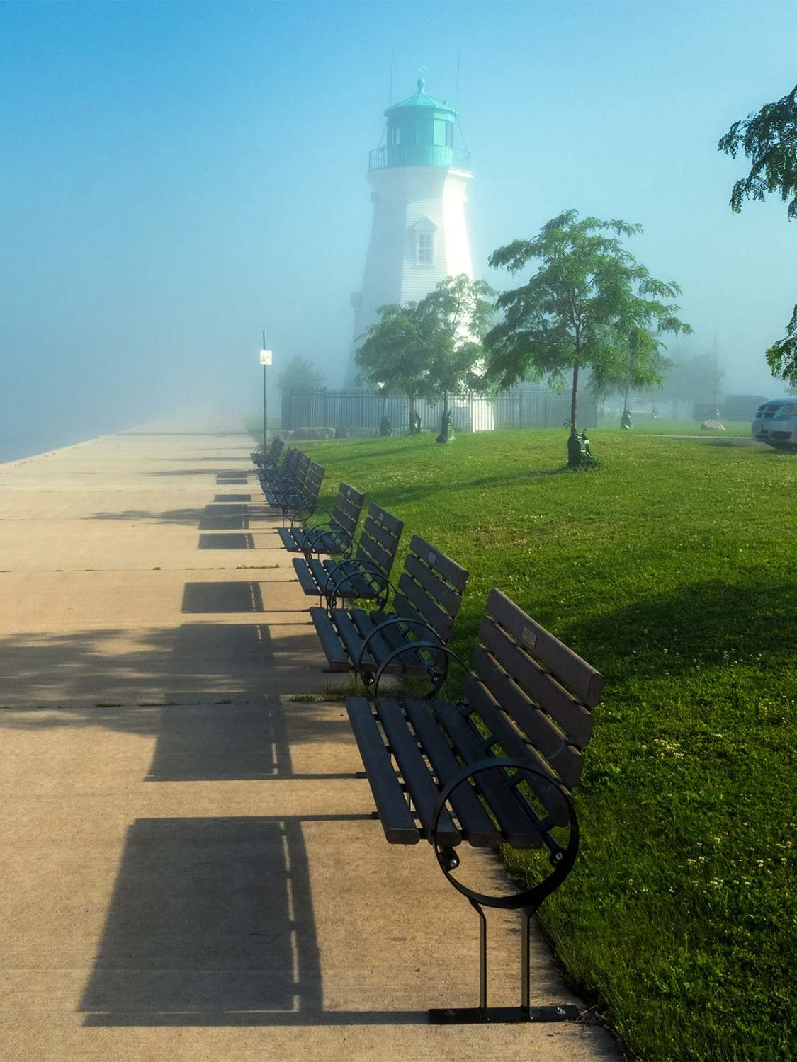 lighthouse park benches foggy waterfront promenade green lawn scenic coastal landmark morning mist