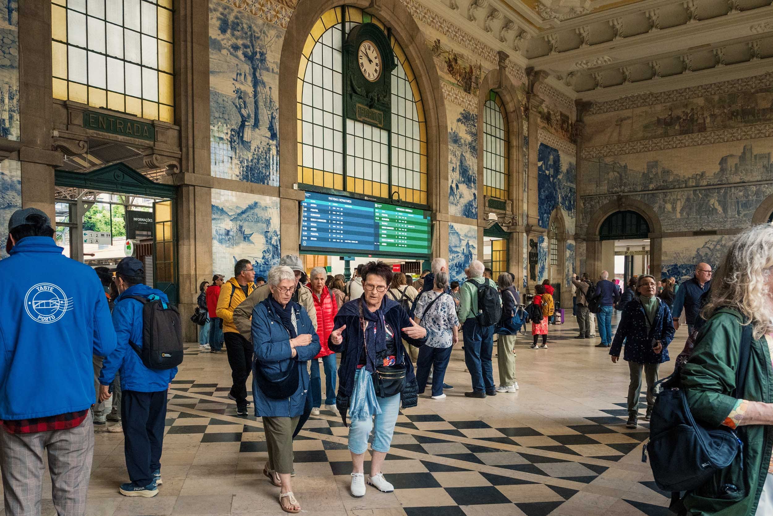 Travelers inside the interior of São Bento train station, Porto
