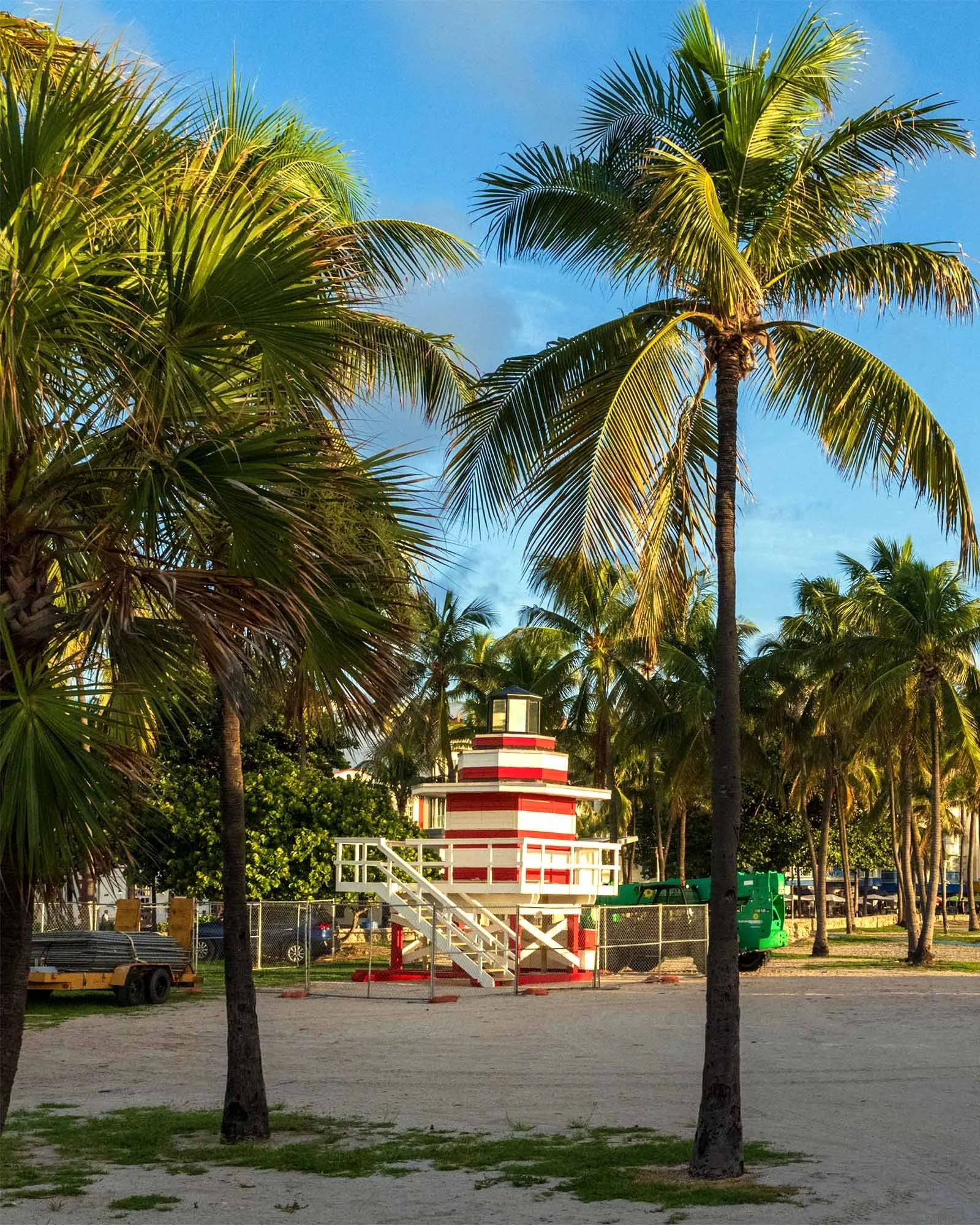 New Jetty lifeguard tower inside a chain-link enclosure among palm trees in Lummus Park, Miami Beach