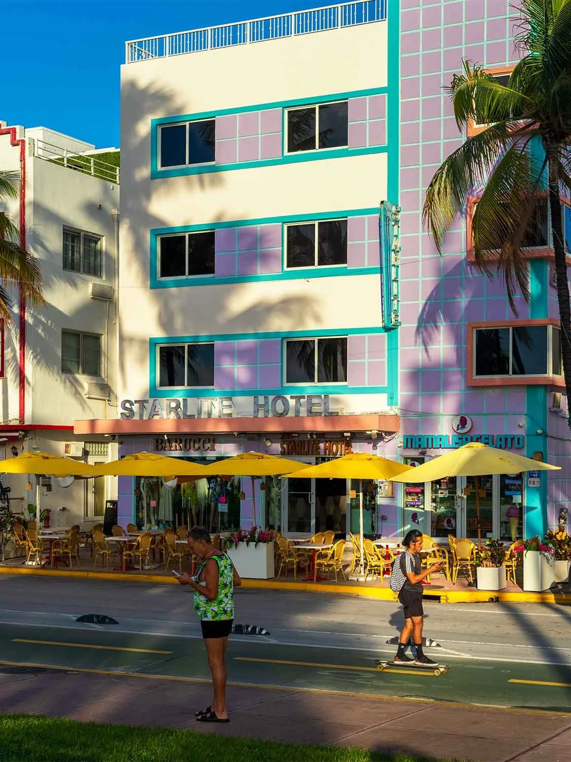 Miami Beach Art Deco hotel Ocean Drive pastel architecture outdoor dining palm trees skateboarding street scene