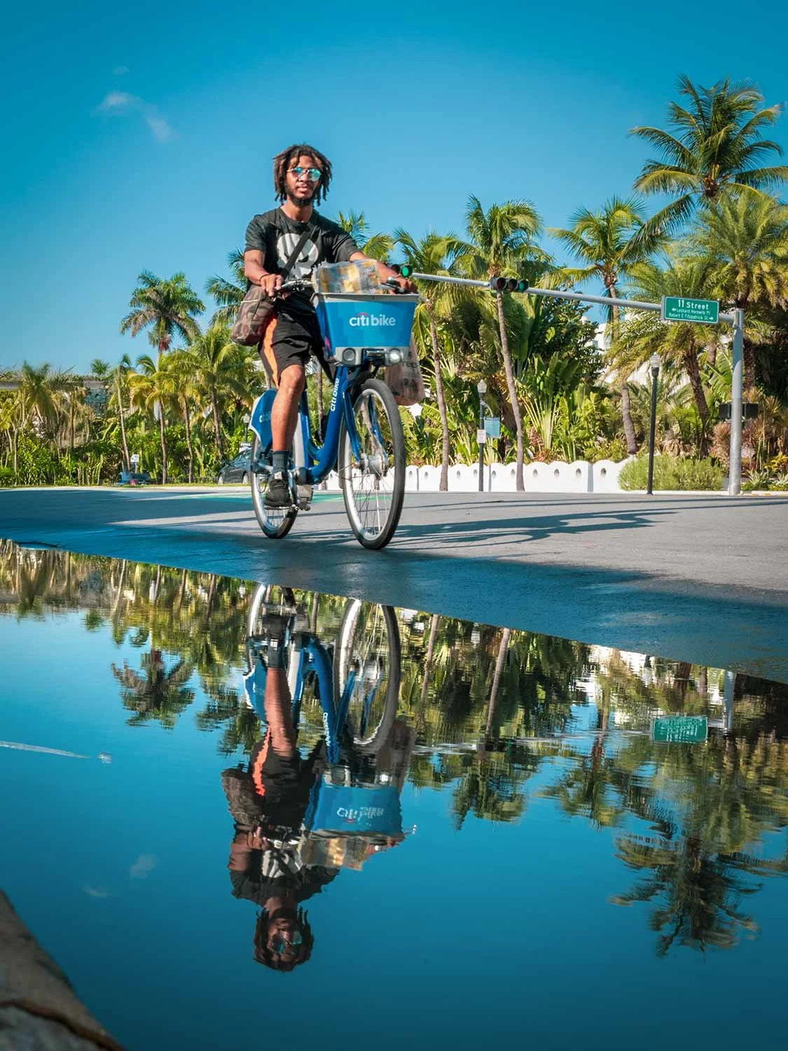 Bike rider on Ocean Drive in South Beach Miami - water reflection by Miami Beach Photographer