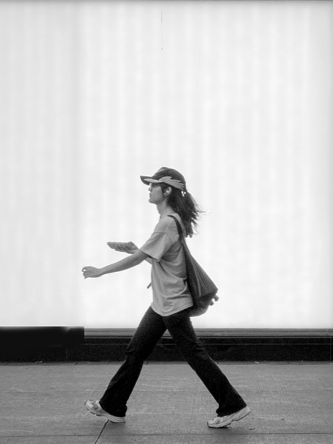 Woman walking across Yonge-Dundas Square, Toronto, black and white street photography