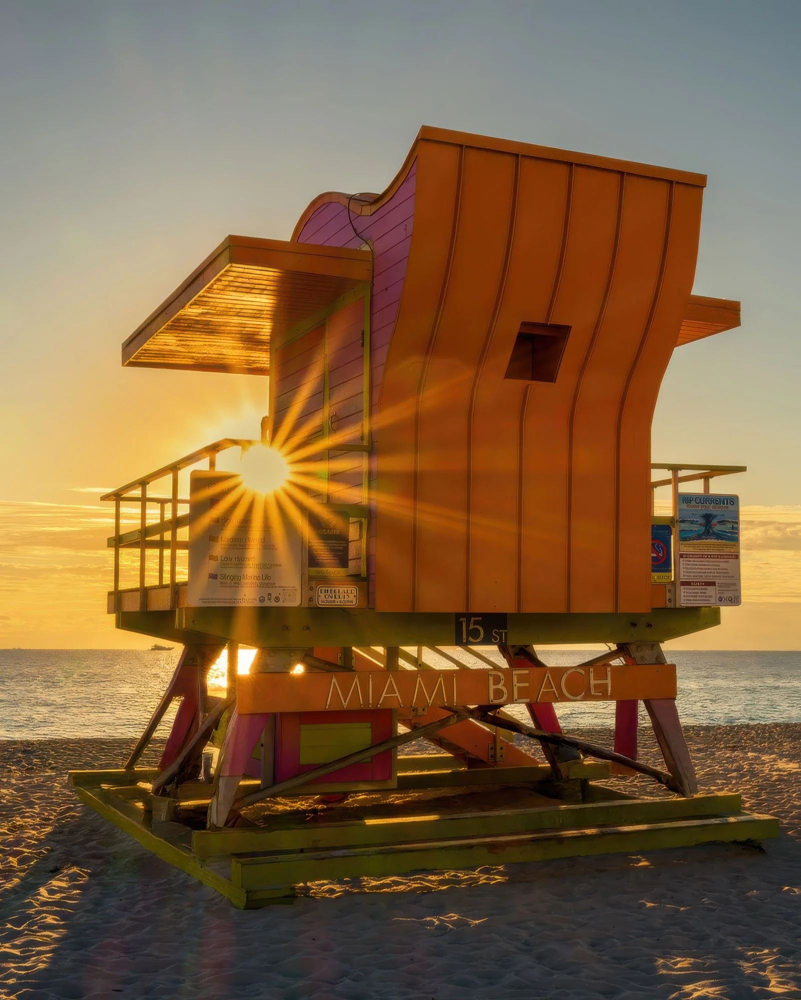 Orange lifeguard stand with a sun flare through its frame, Miami Beach