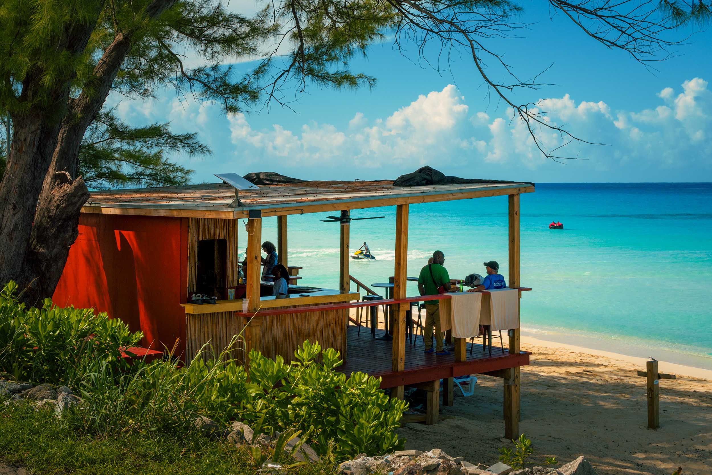 Tourists enjoying a drink in beach shack in Bimini Bahamas