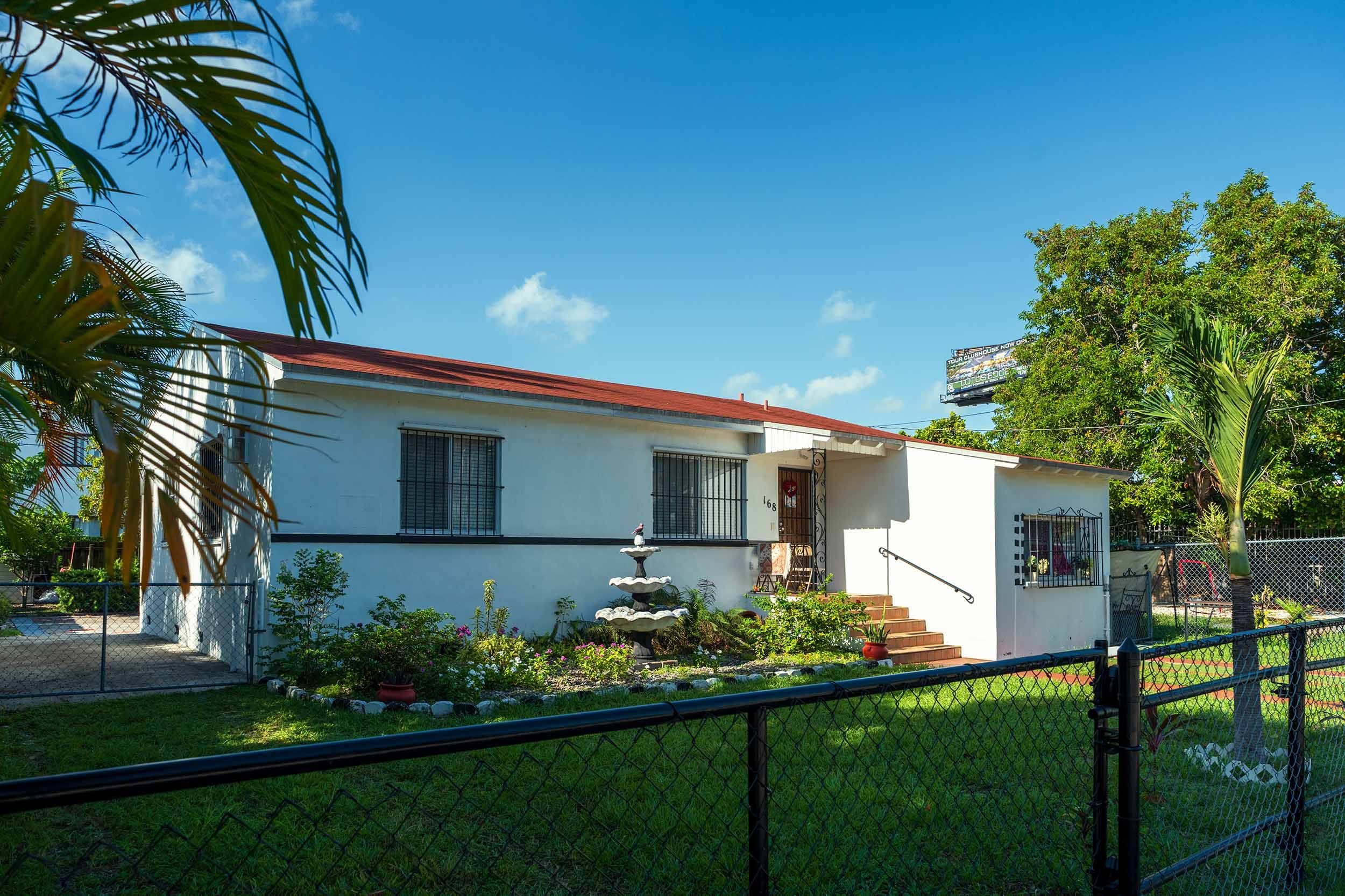 White single-story home with tiered fountain in front yard, Buena Vista Miami
