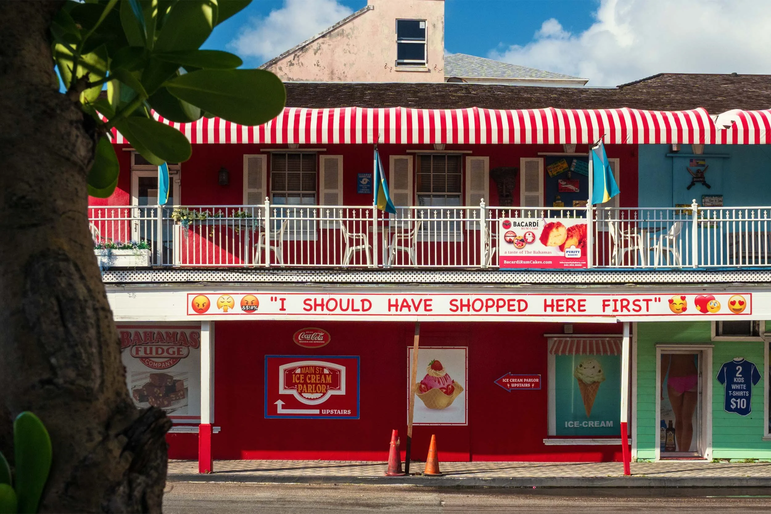 Bahamas Fudge Company ice cream parlor Nassau tourist shop red striped awning Bahamian flags souvenir store