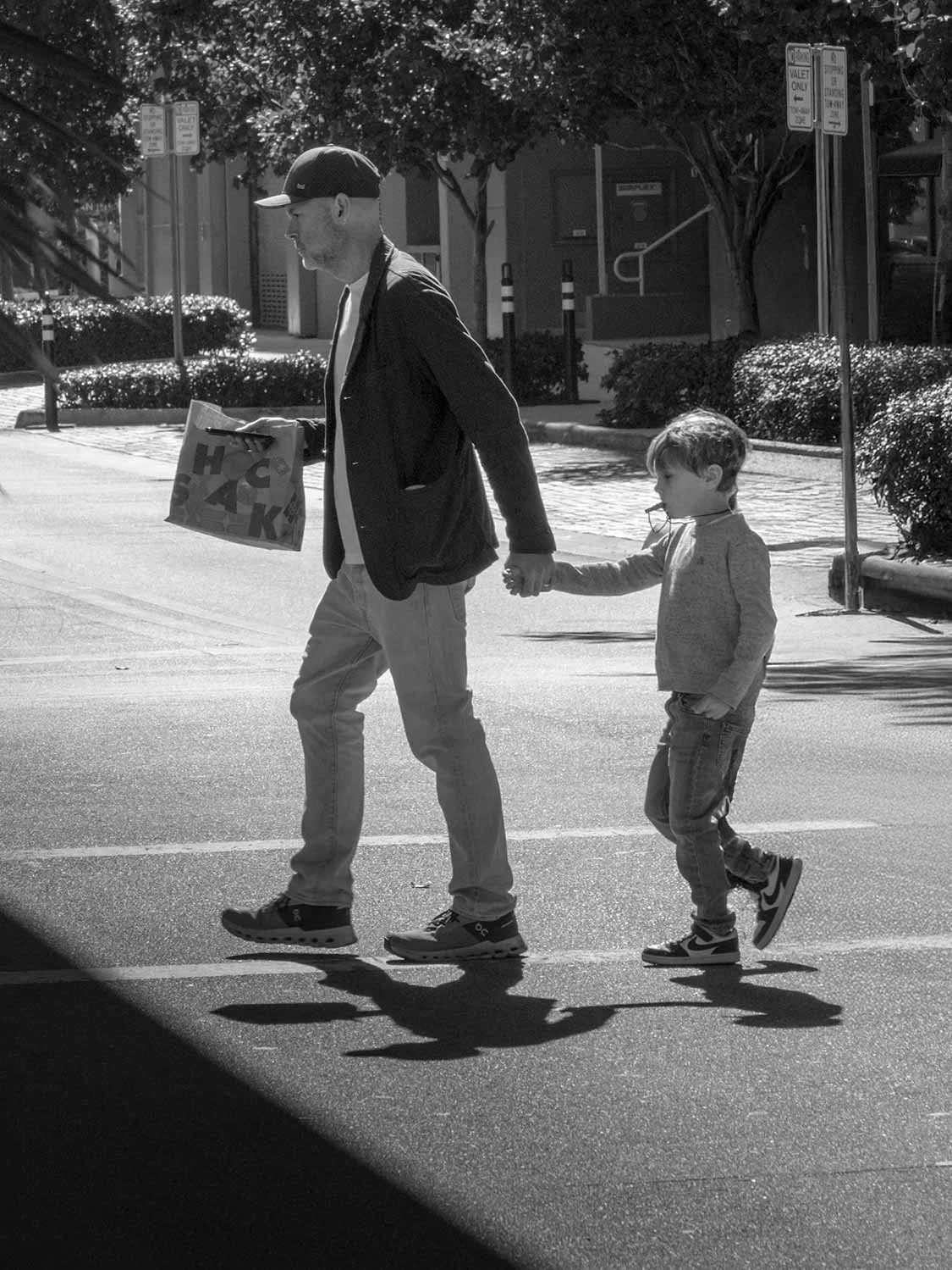 father son street photography downtown Miami crosswalk black white urban family moment
