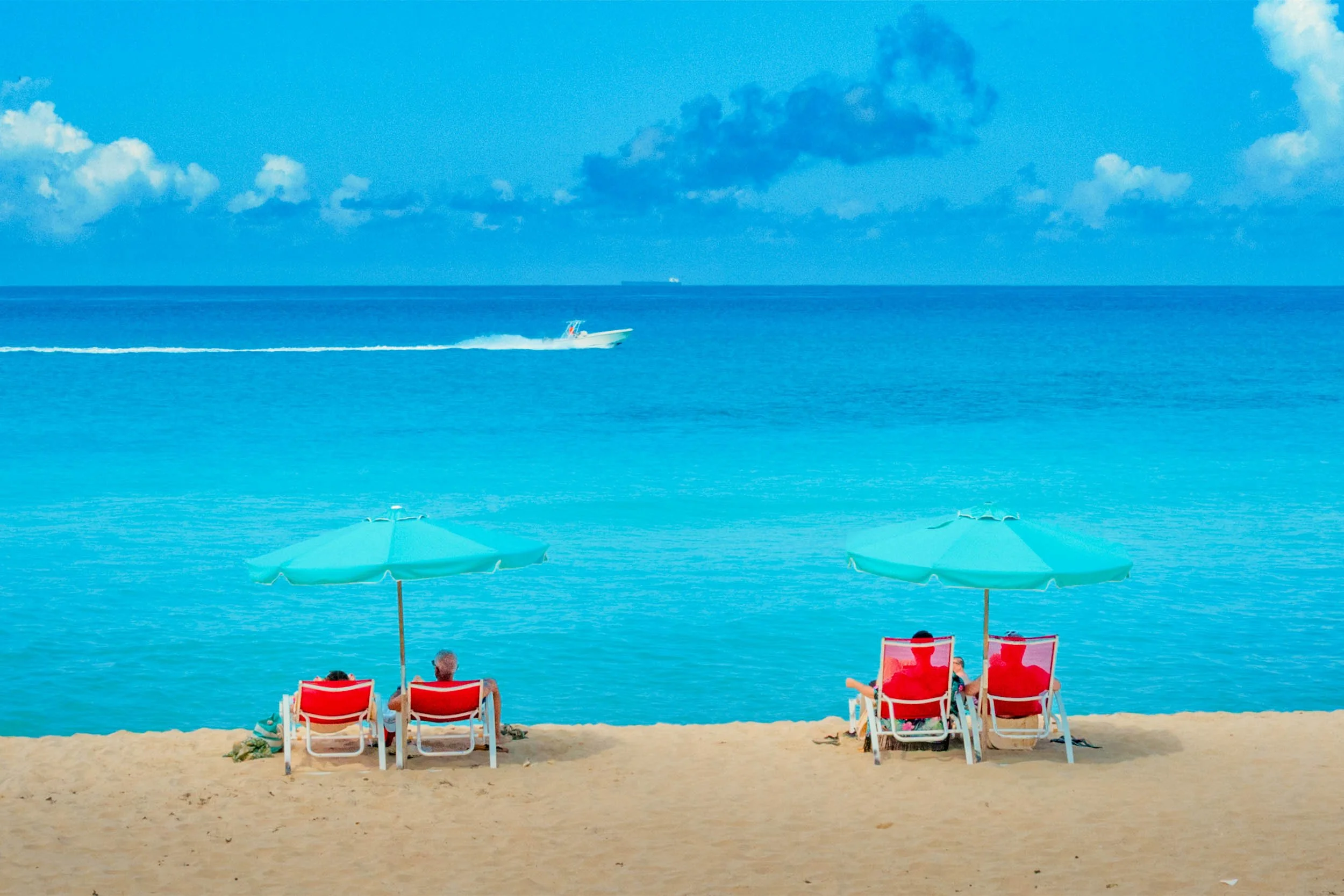 Enjoying the beautiful waters of Bimini Bahamas sitting under umbrellas on the beach