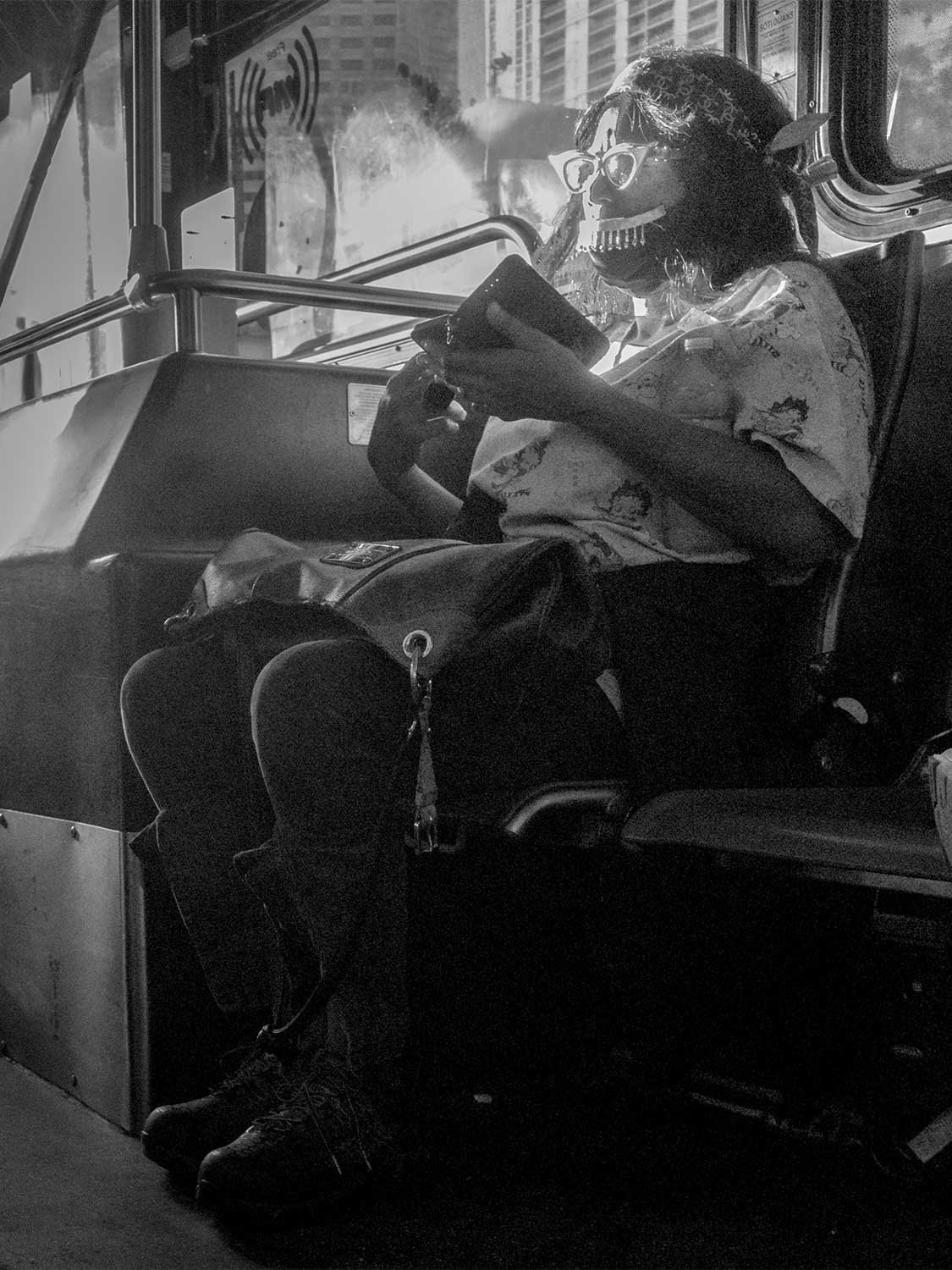 Woman riding the bus in Little Havana, Miami, backlit black and white street portrait