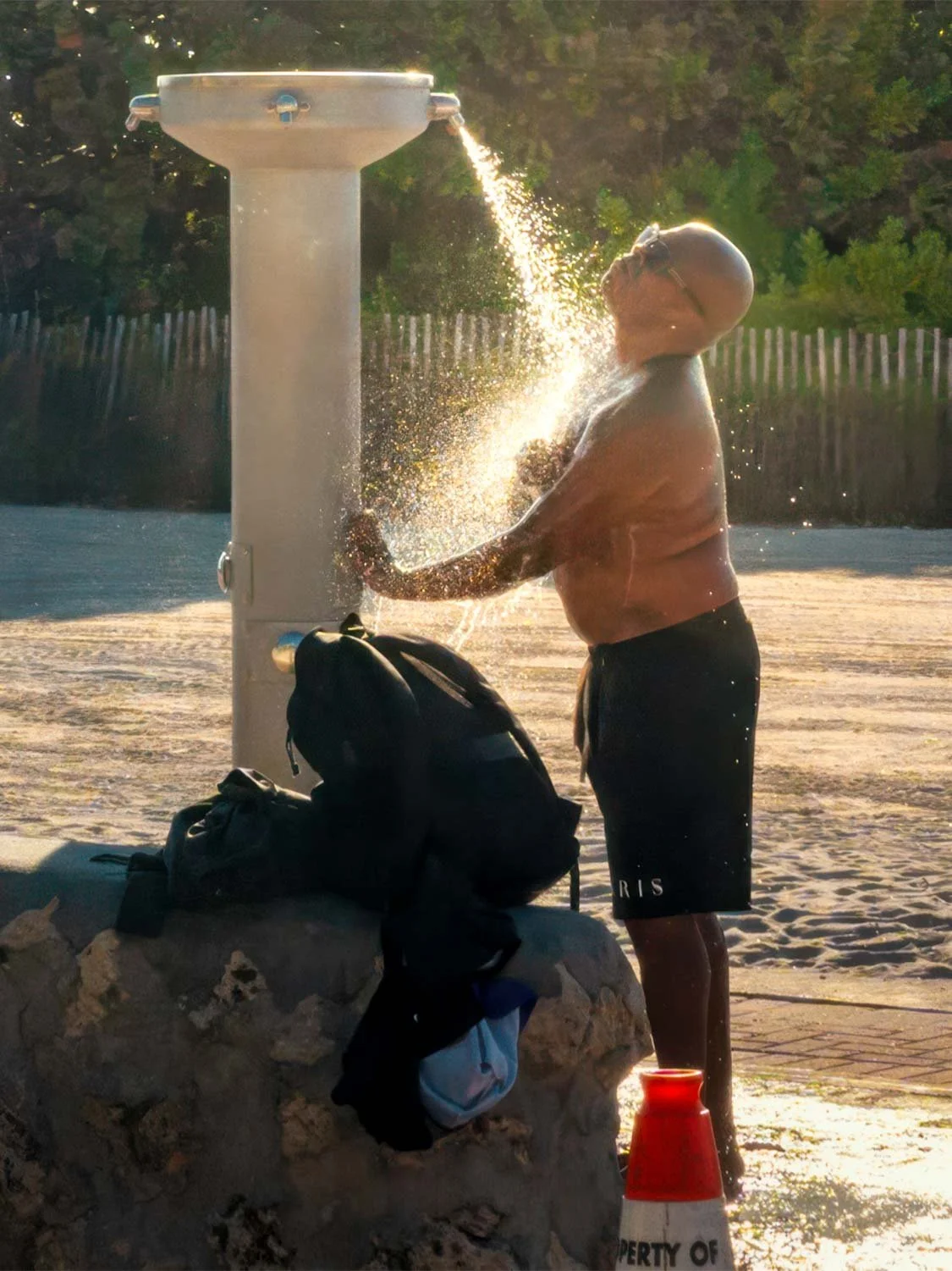 South Beach outdoor shower station man washing off sand after swim golden hour beach lifestyle