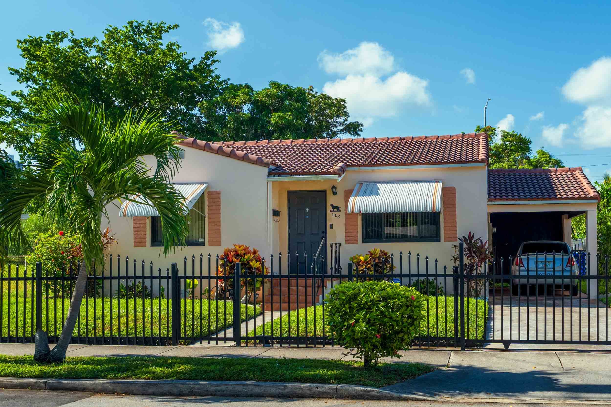 Cream stucco home with striped awnings and terracotta roof, Buena Vista Miami