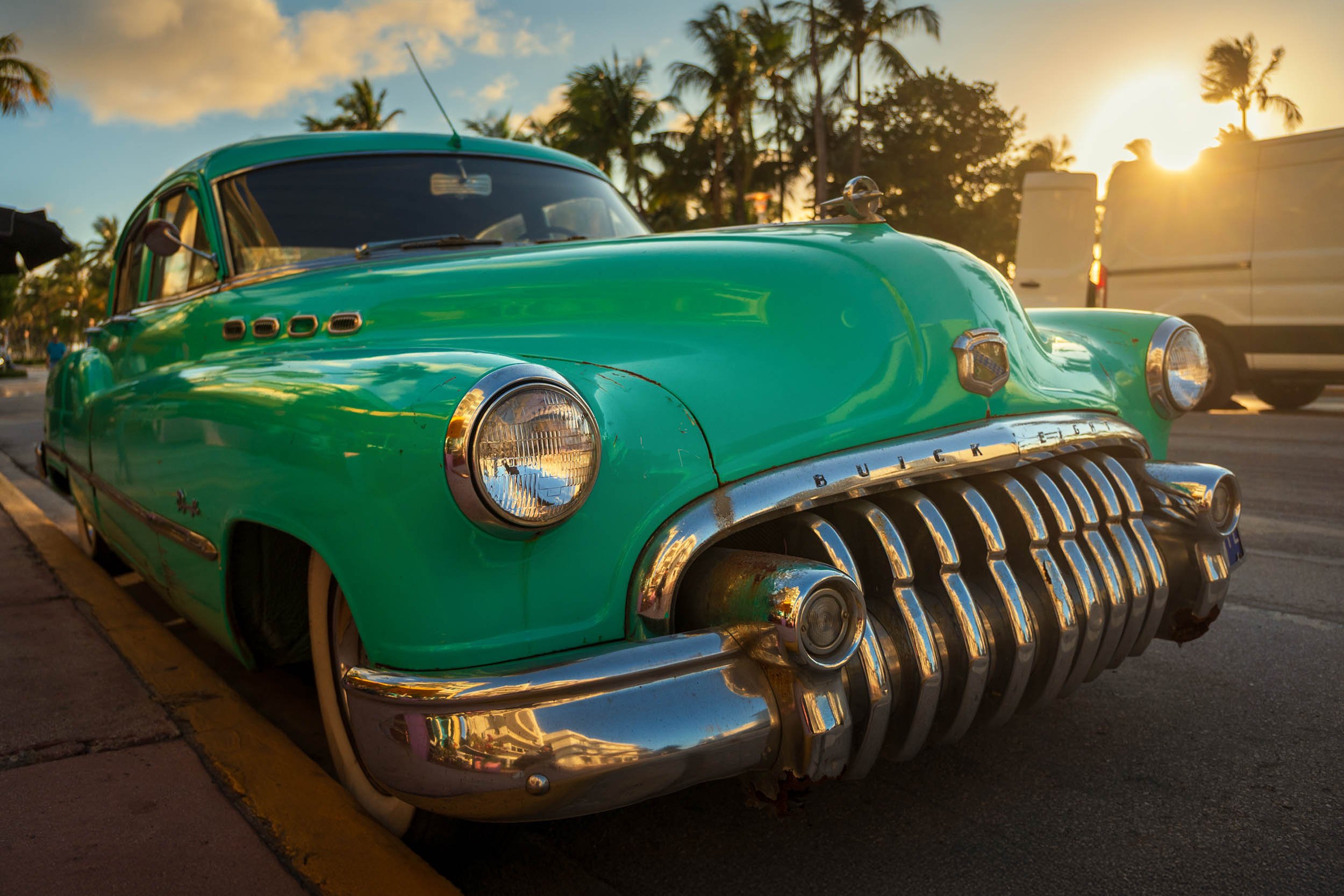 The morning sun reflects off a classic car parked on Ocean Drive in South Beach Miami