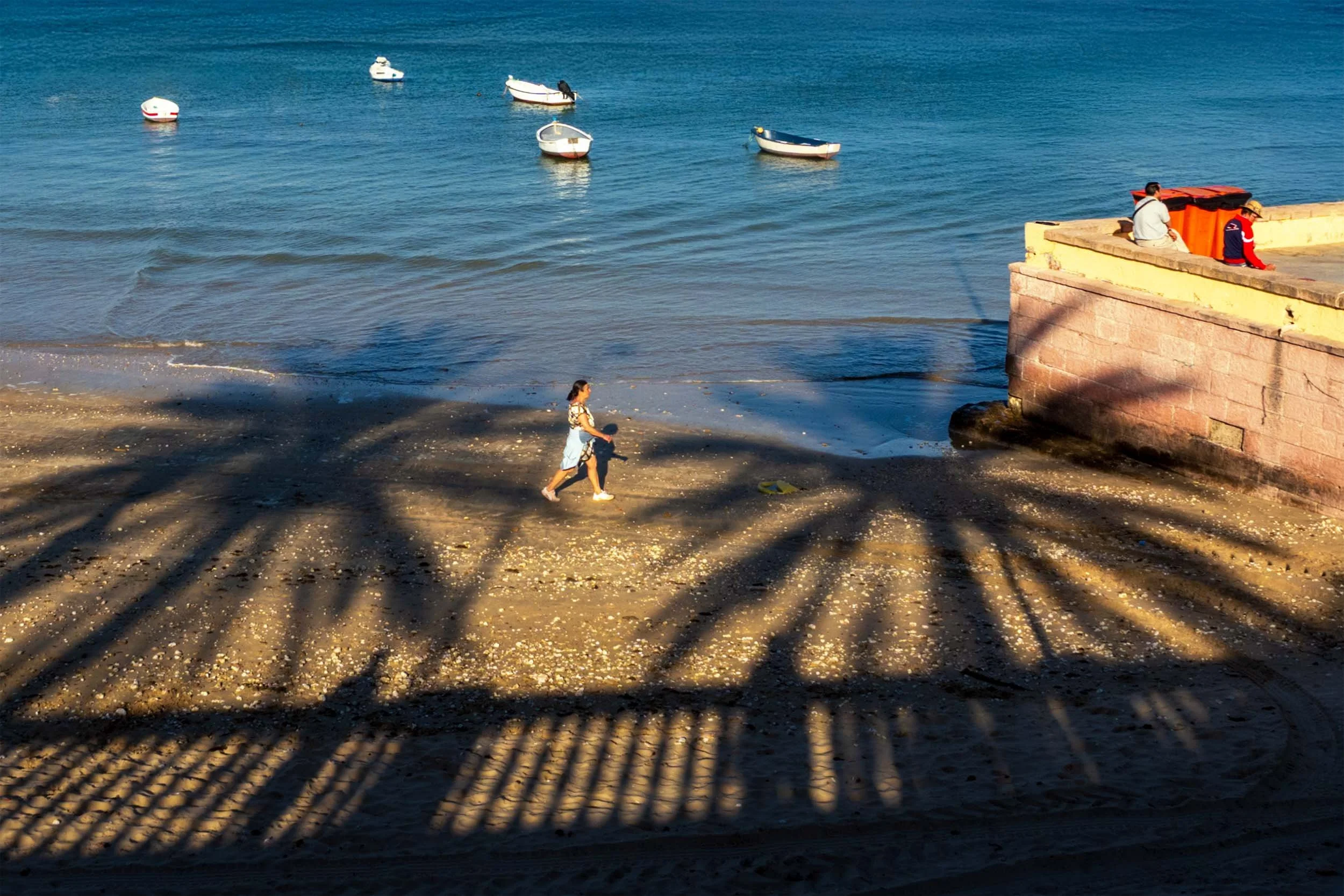 Cadiz Spain beach photography palm shadow woman walking seaside boats Mediterranean travel destination