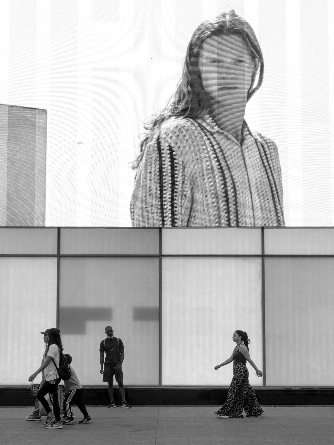 Pedestrians walking beneath giant advertising display at Yonge-Dundas Square, Toronto