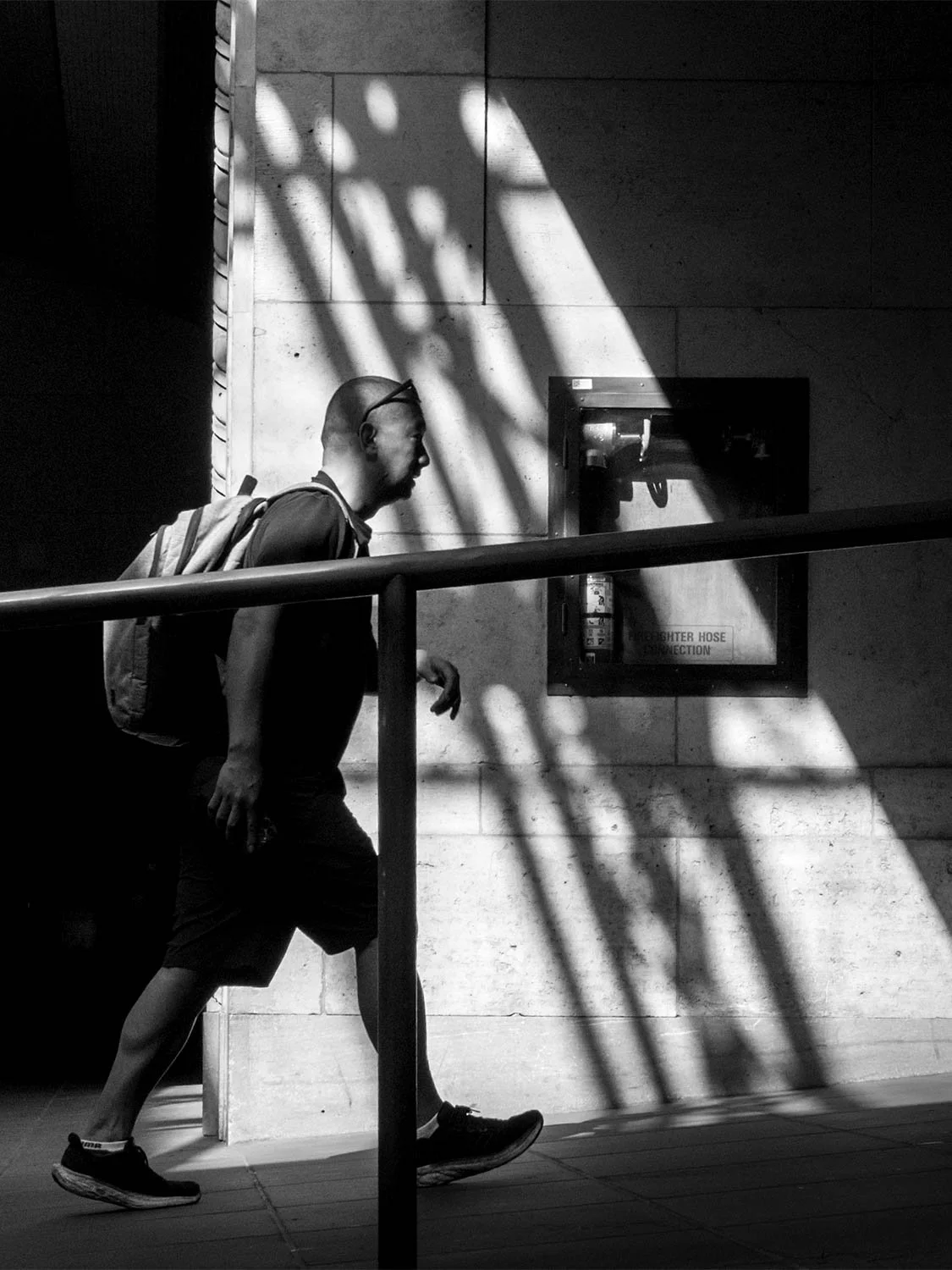Pedestrian walking through dramatic light and shadow at Union Station, Toronto