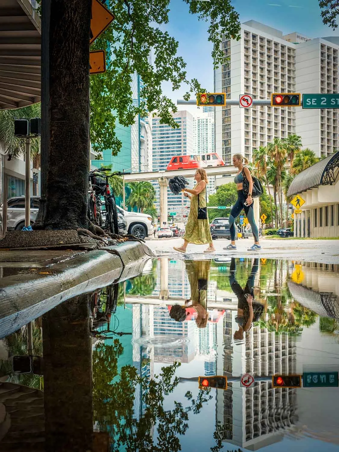 People walking by a puddle creating a water reflection in downtown Miami