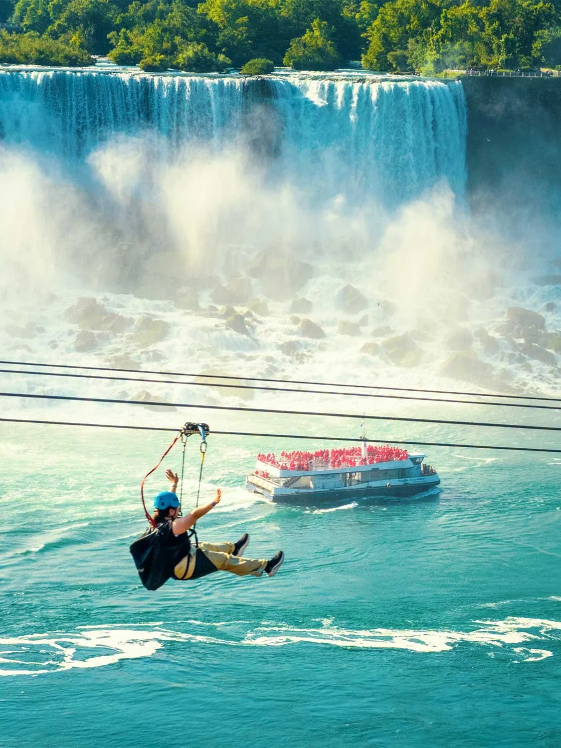 Niagara Falls zip line adventure tour over turquoise gorge river with Hornblower boat and American Falls