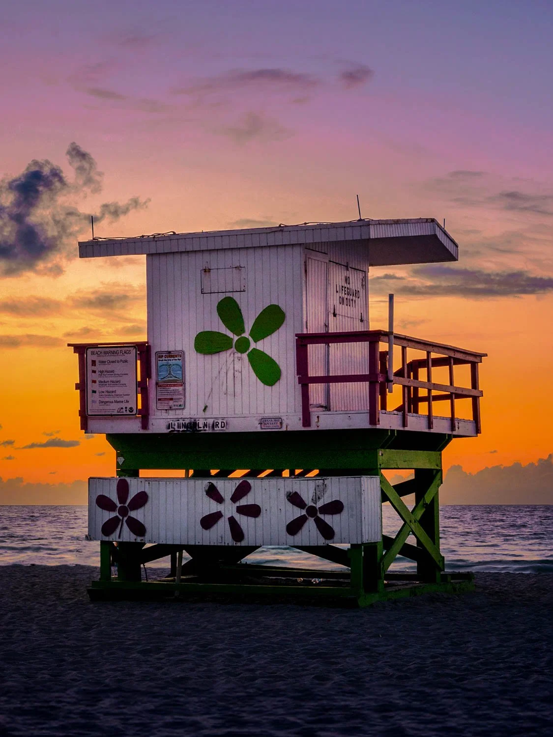 Miami Beach lifeguard stand with green flower design at Lincoln Road at vibrant orange and purple sunset